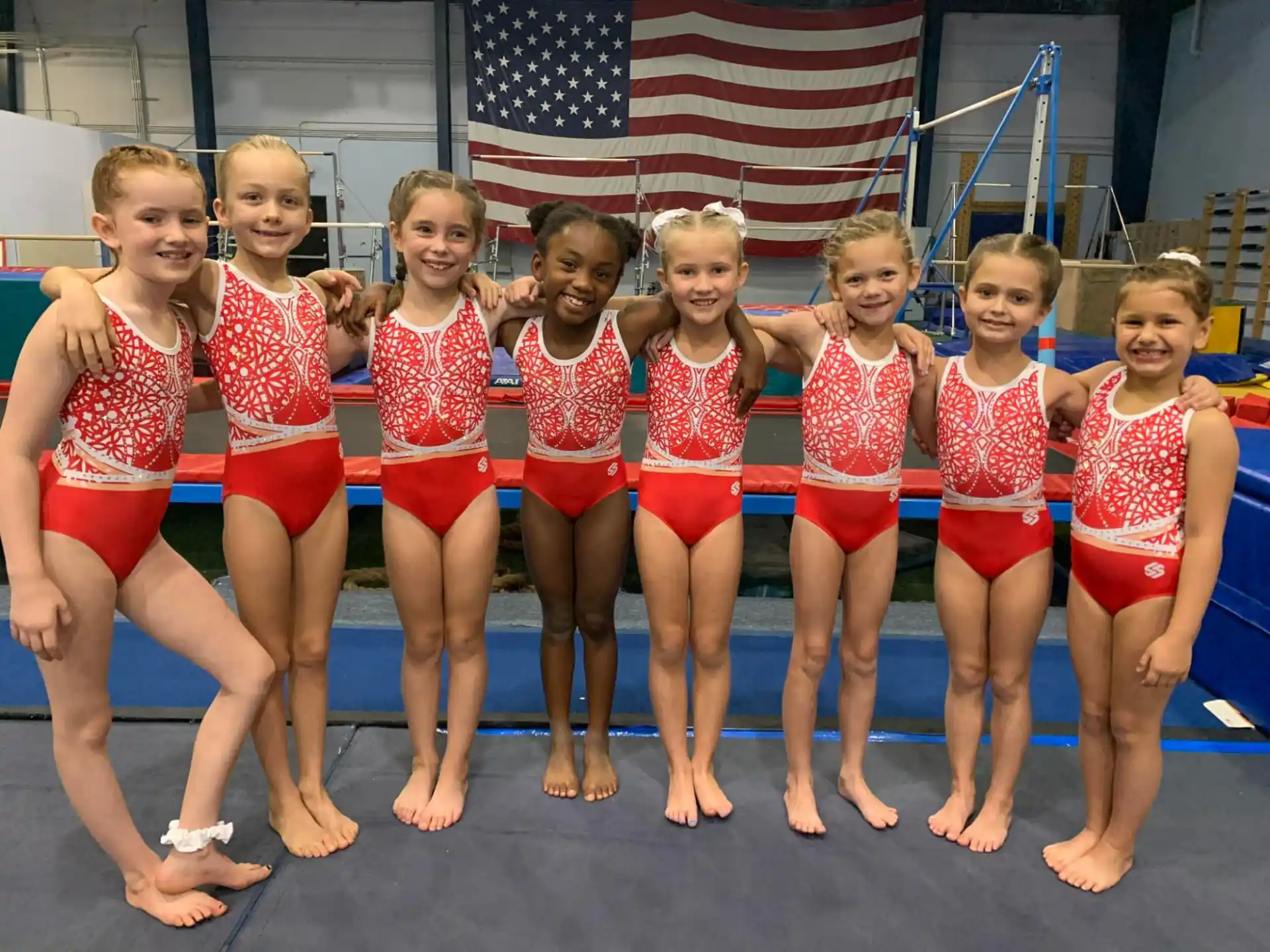 a group of girls in red and white swimsuits posing for a photo