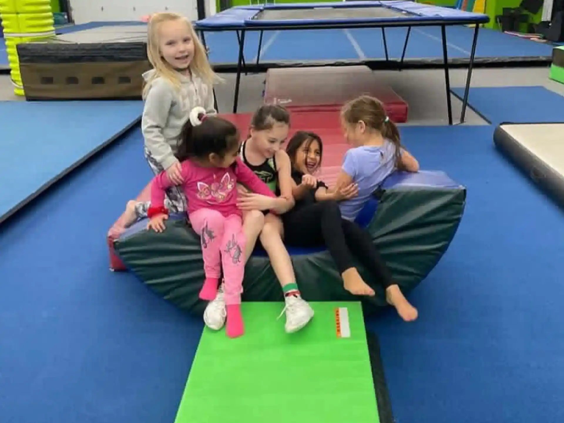 a group of children sitting on a mat in a room