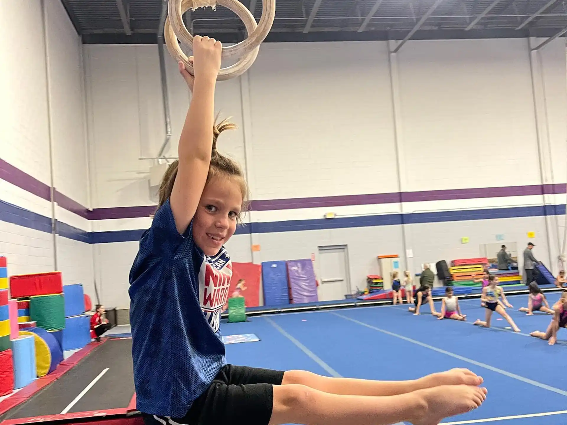 a person doing a handstand on a mat in a gym
