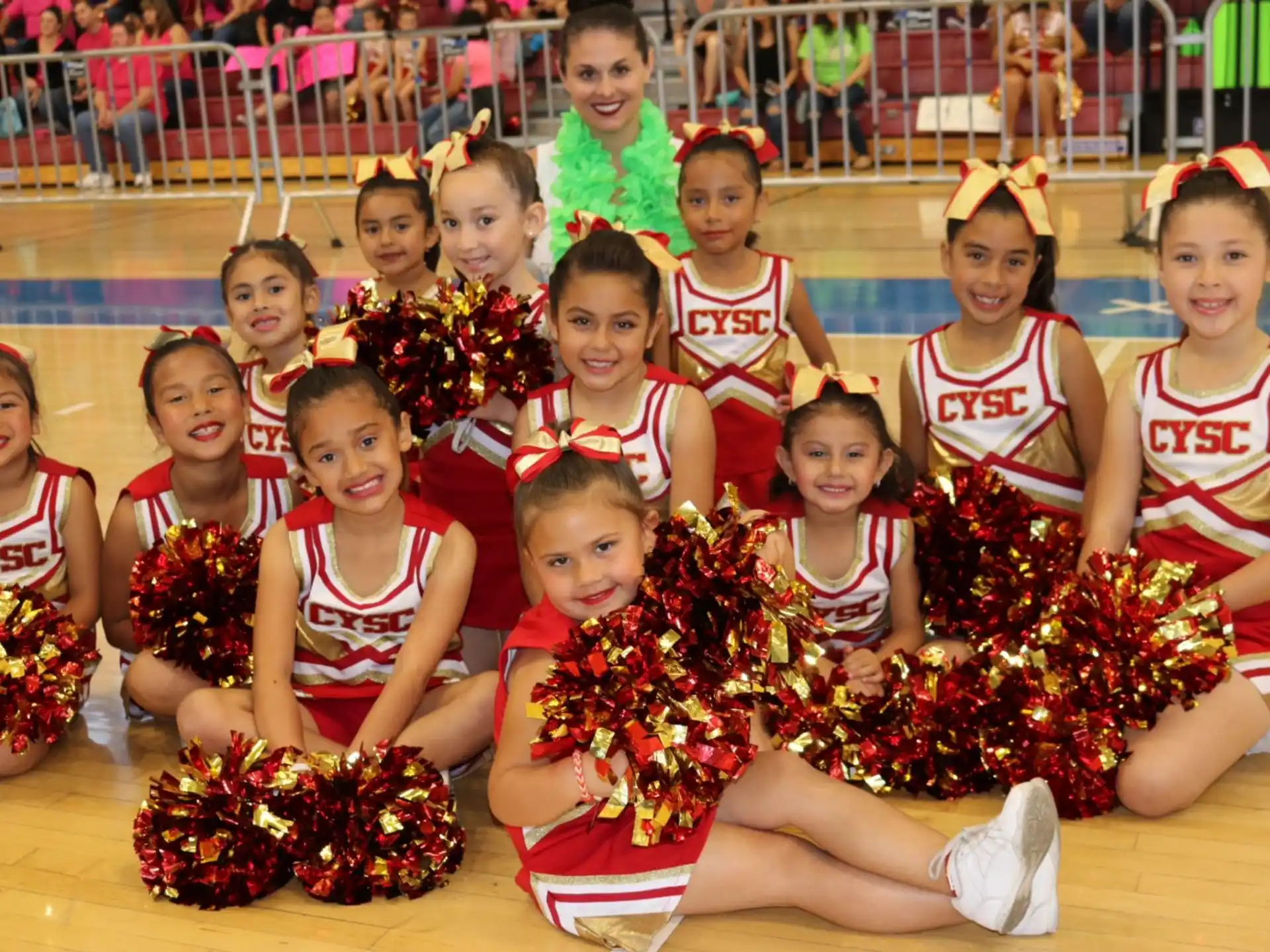 a group of girls in red and white uniforms sitting on the ground
