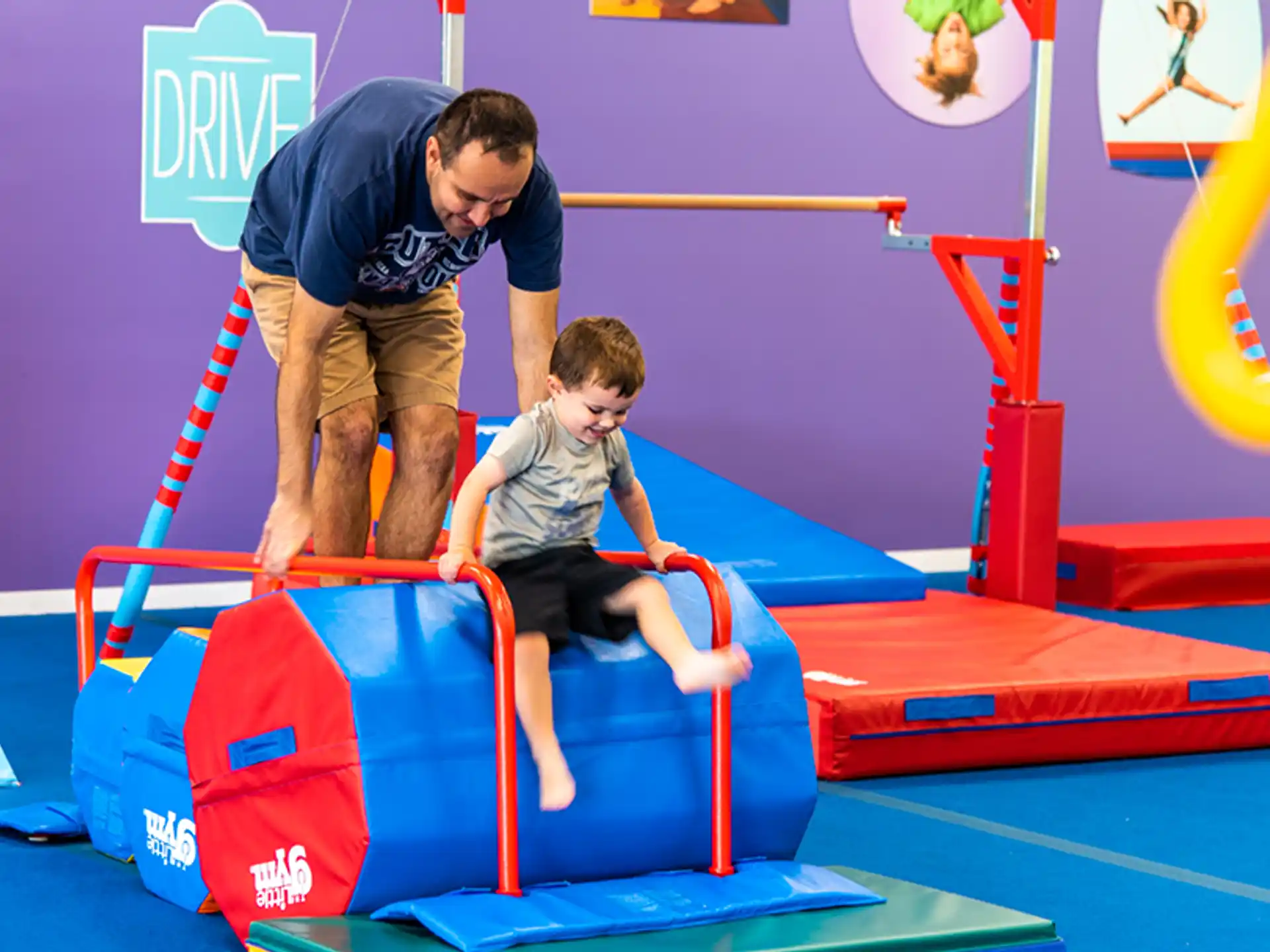 a person and a boy playing on a toy