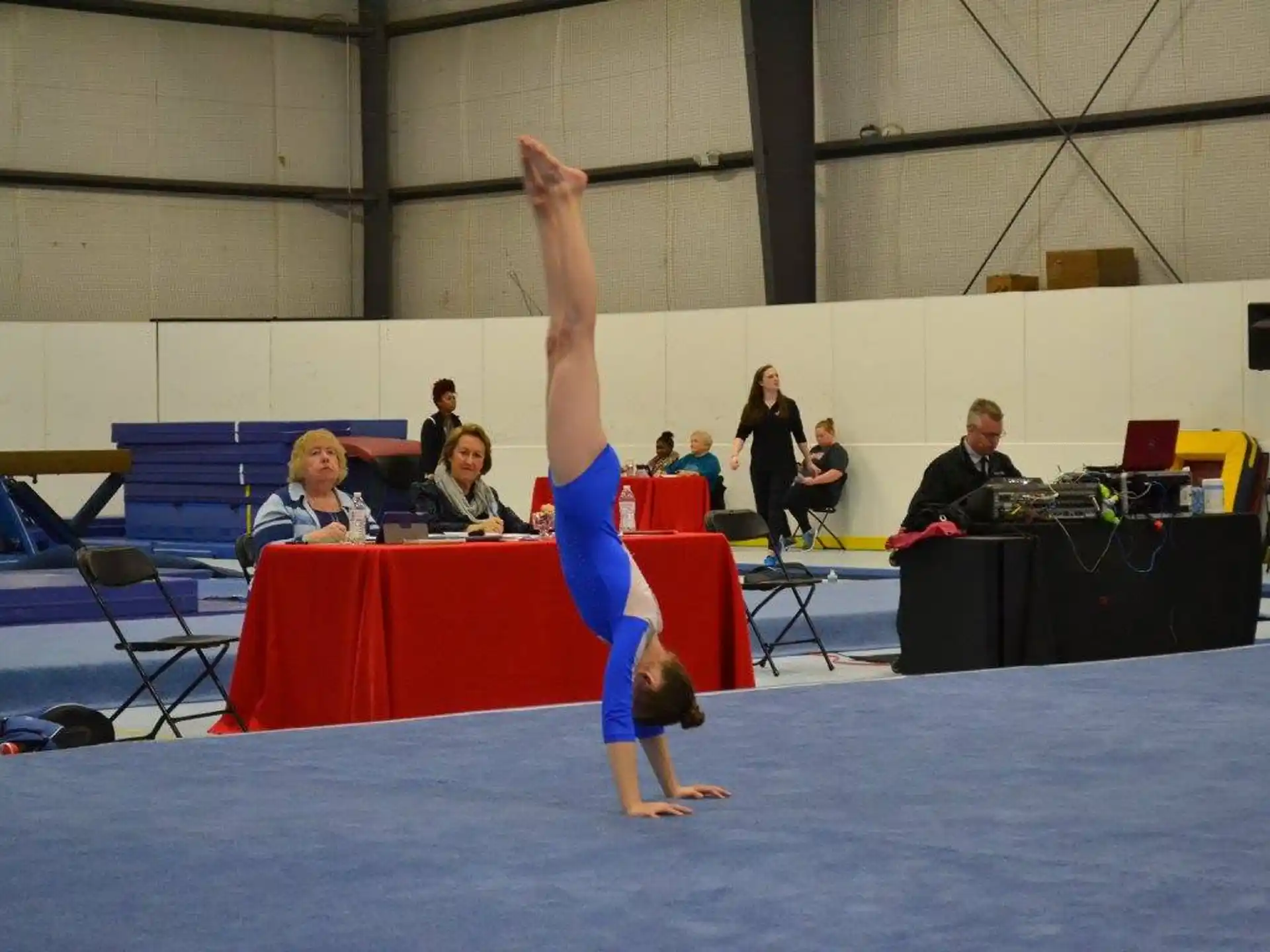 a person doing a handstand on a mat in front of a crowd
