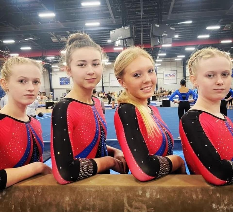a group of girls in leotards posing for a photo
