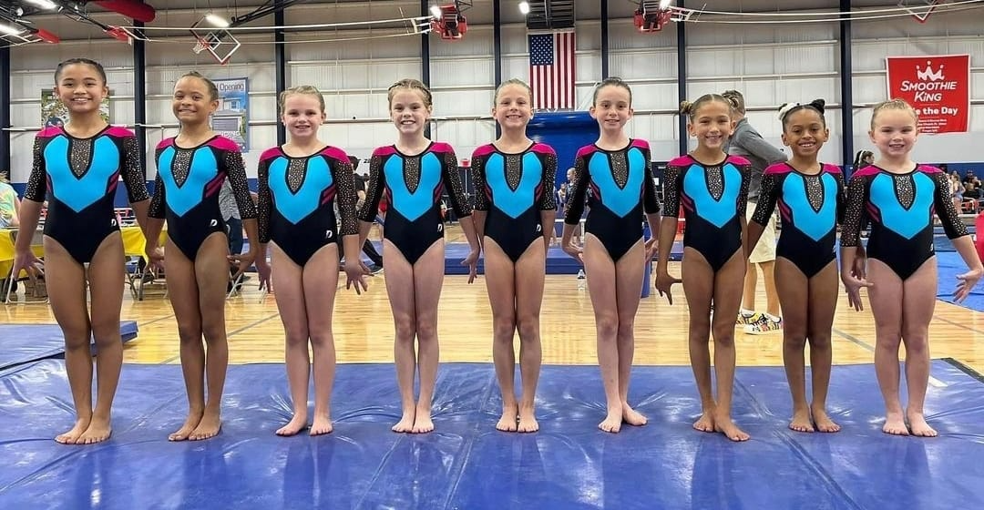 a group of women in leotards posing for a photo