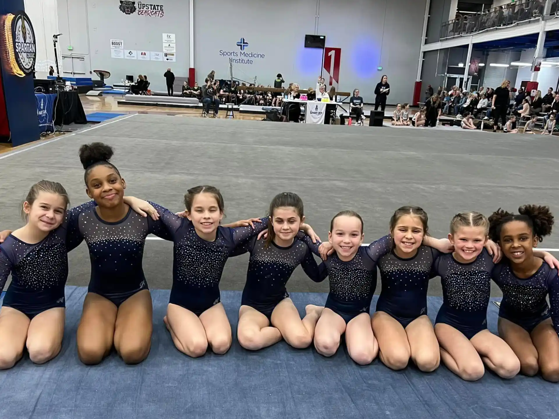 a group of girls in leotards posing for a photo