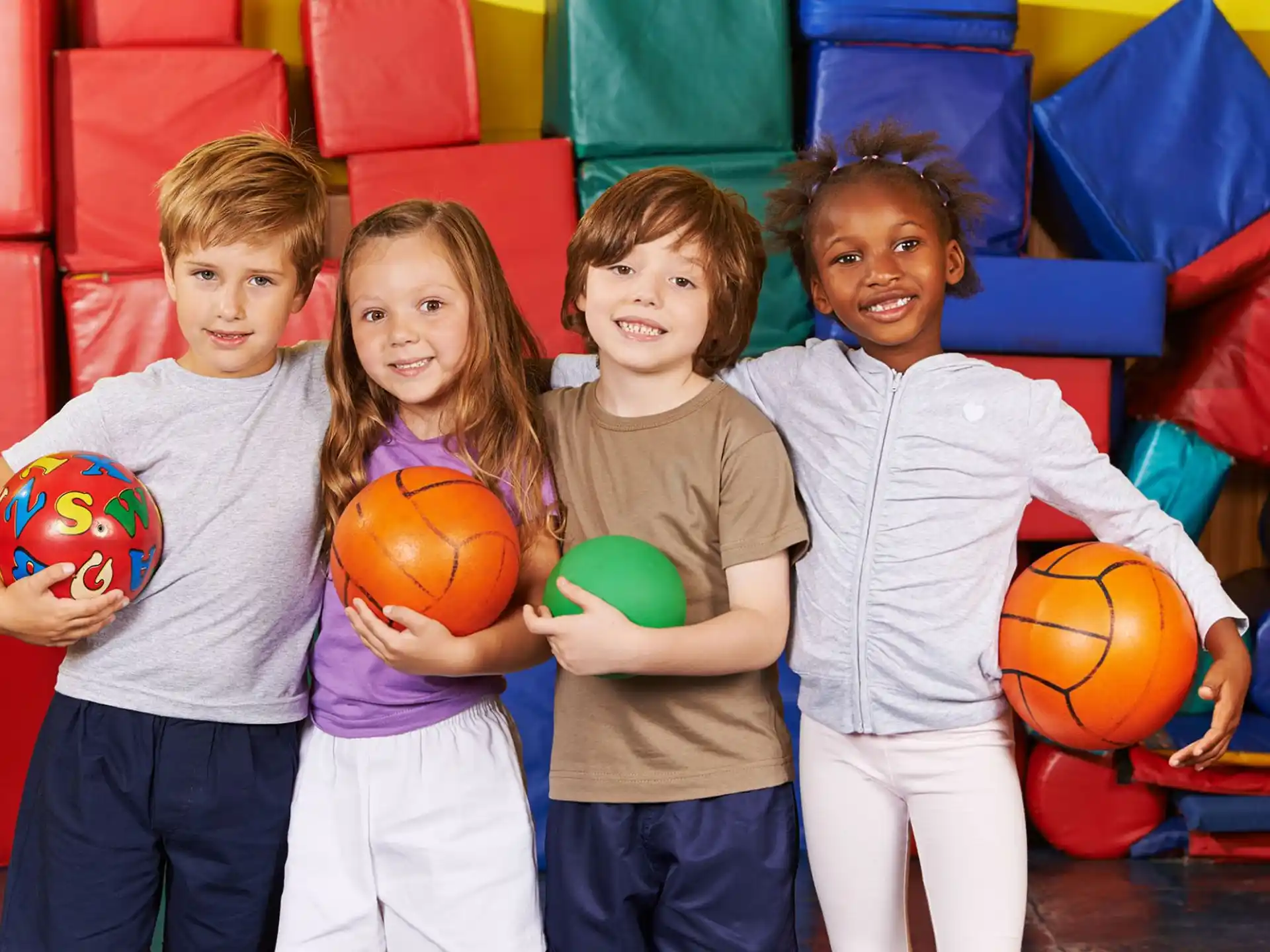 a group of children holding basketballs
