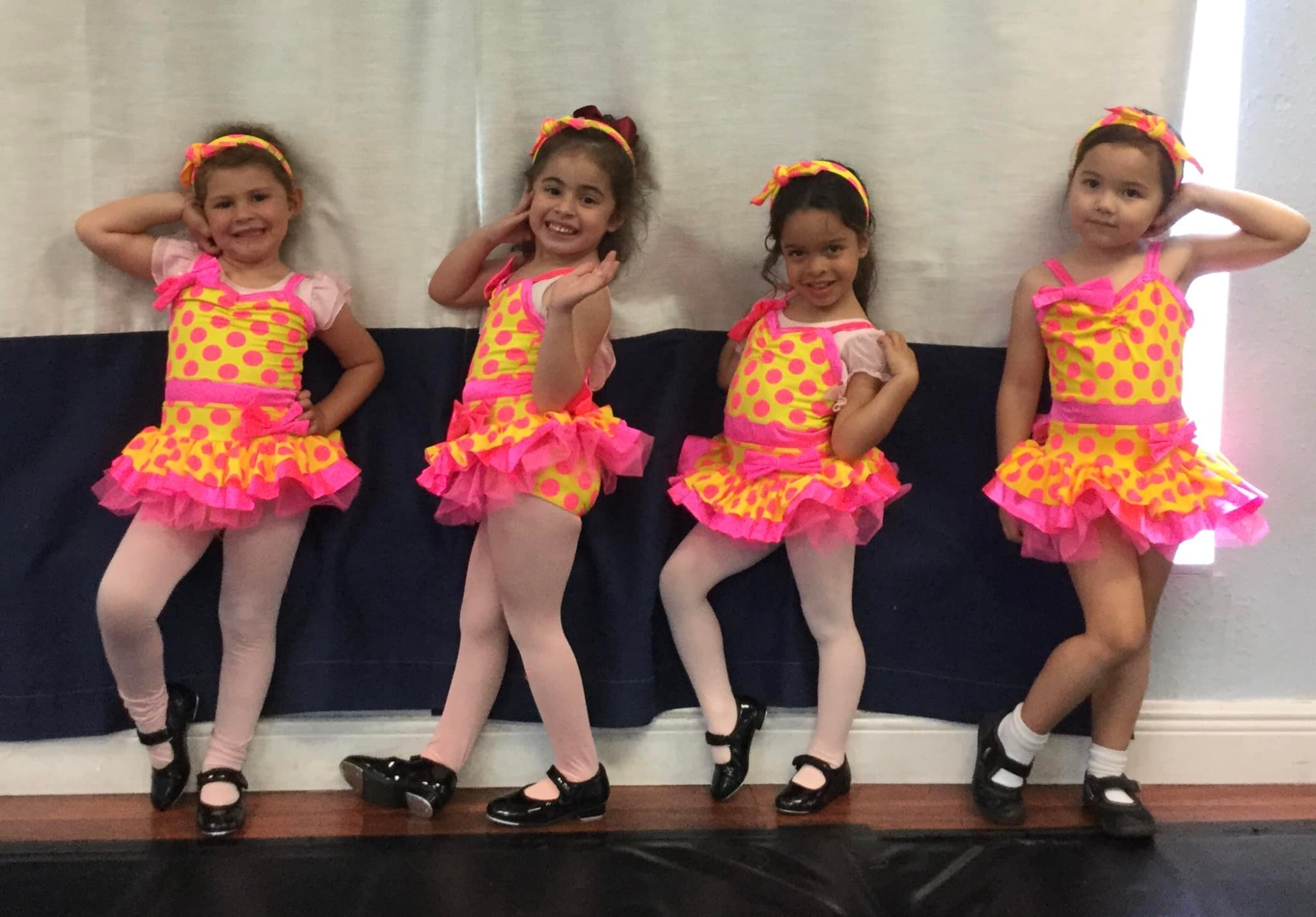 a group of girls in colorful dresses