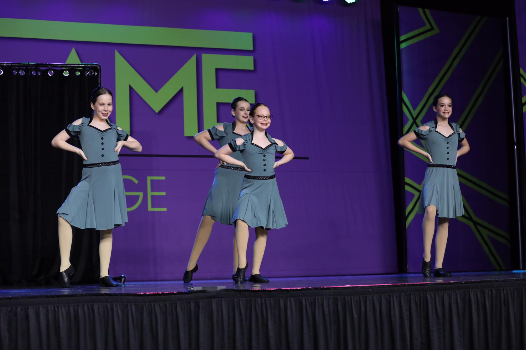 a group of women in dresses on a stage
