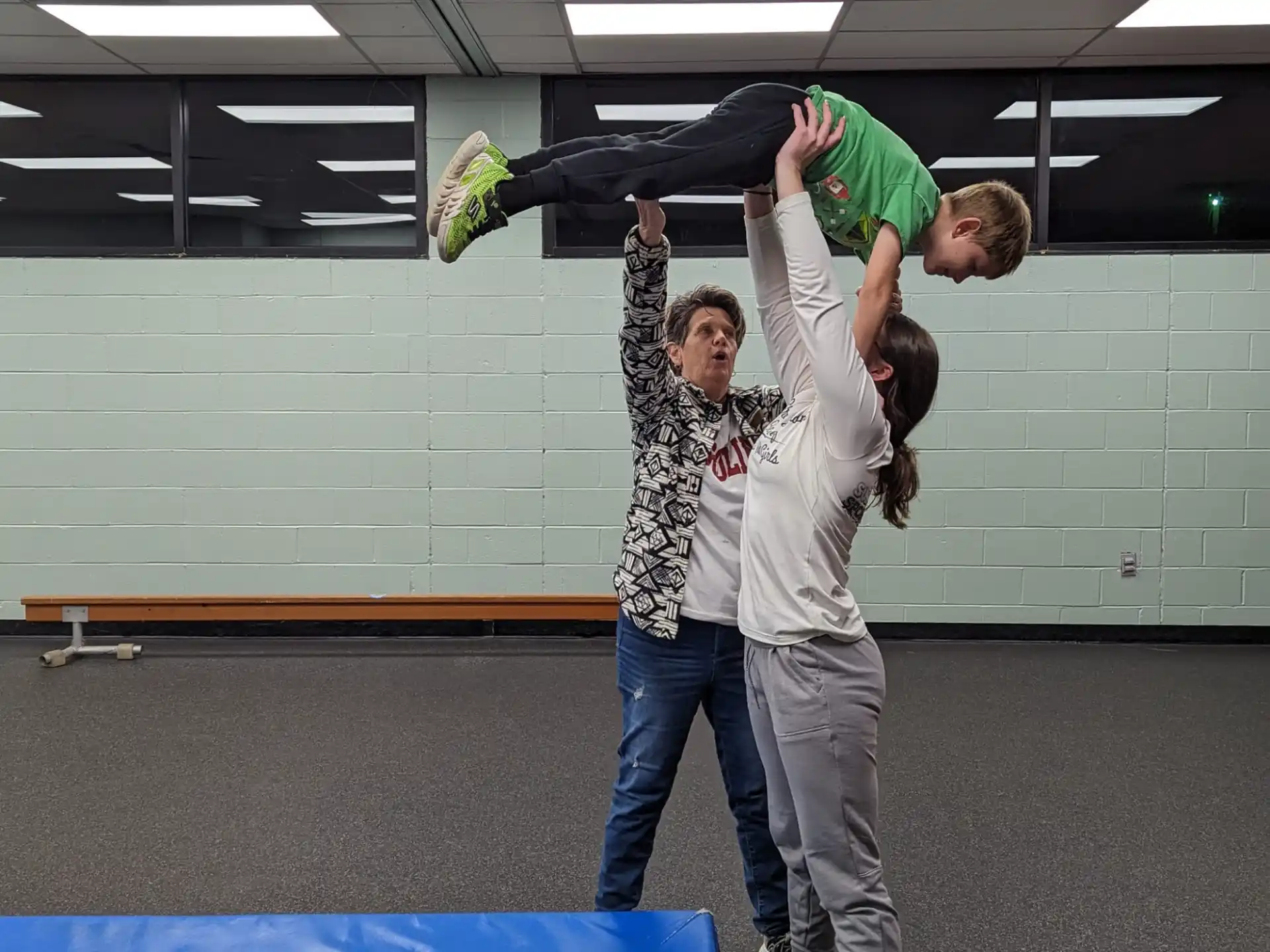 a man and a woman holding a girl in the air