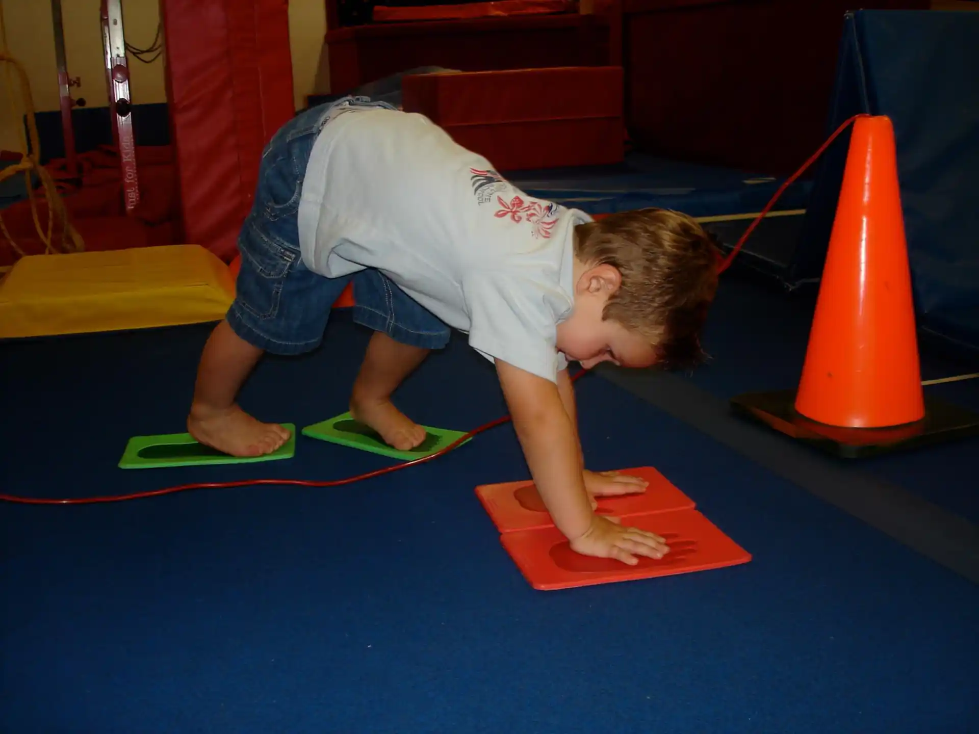 a boy doing a push up on a mat
