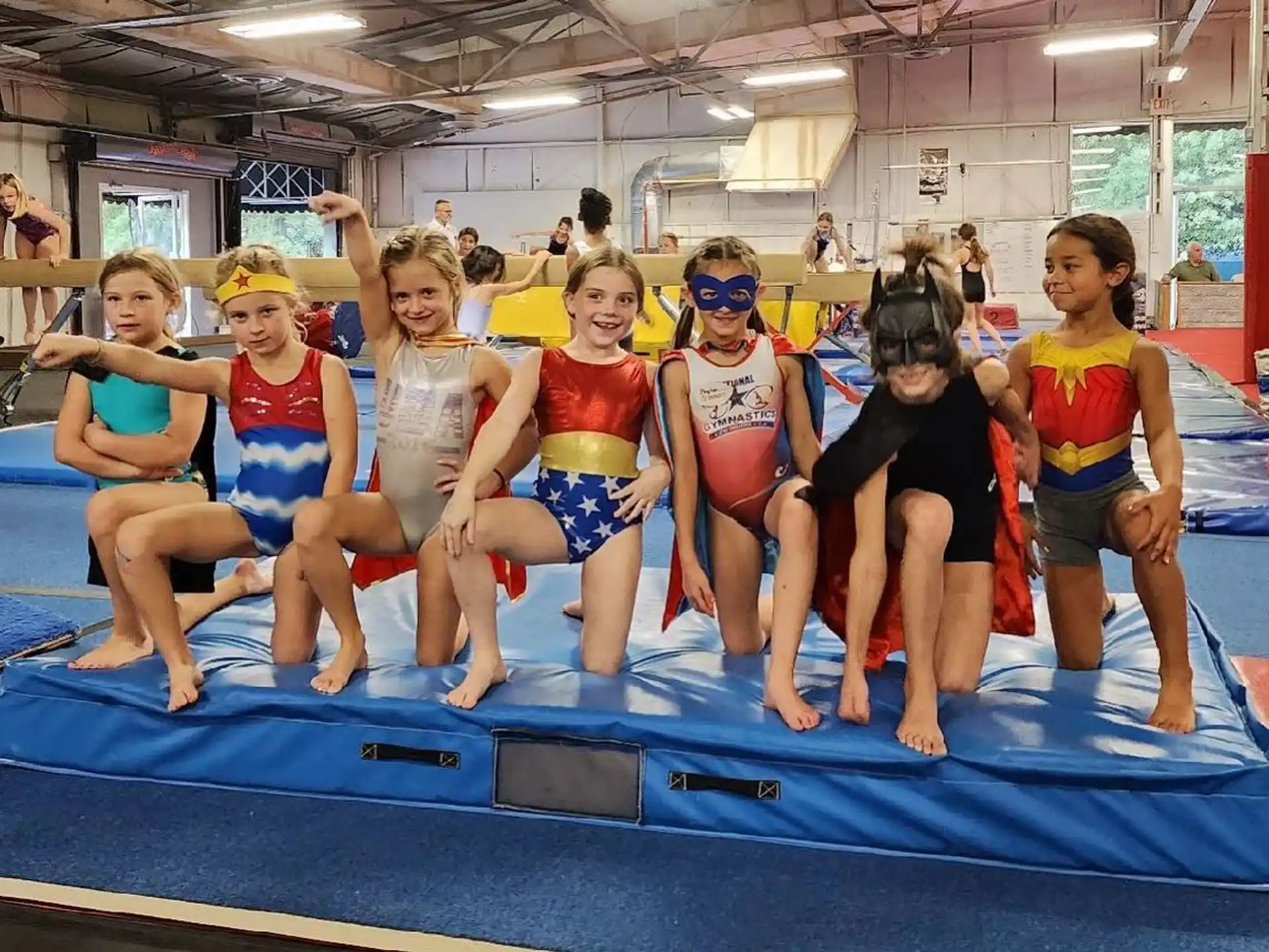 a group of kids in swimsuits on a blue mat