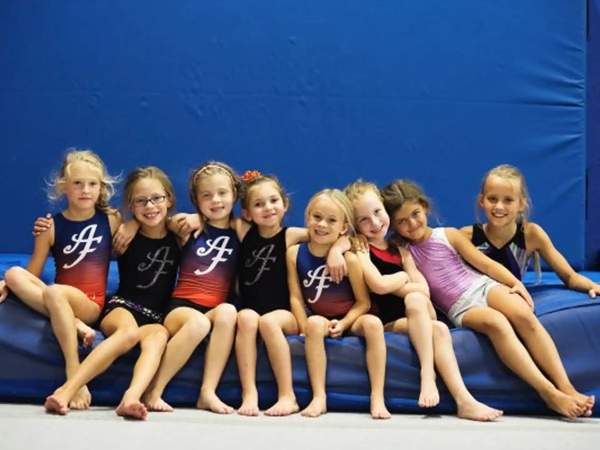 a group of girls sitting on a stage