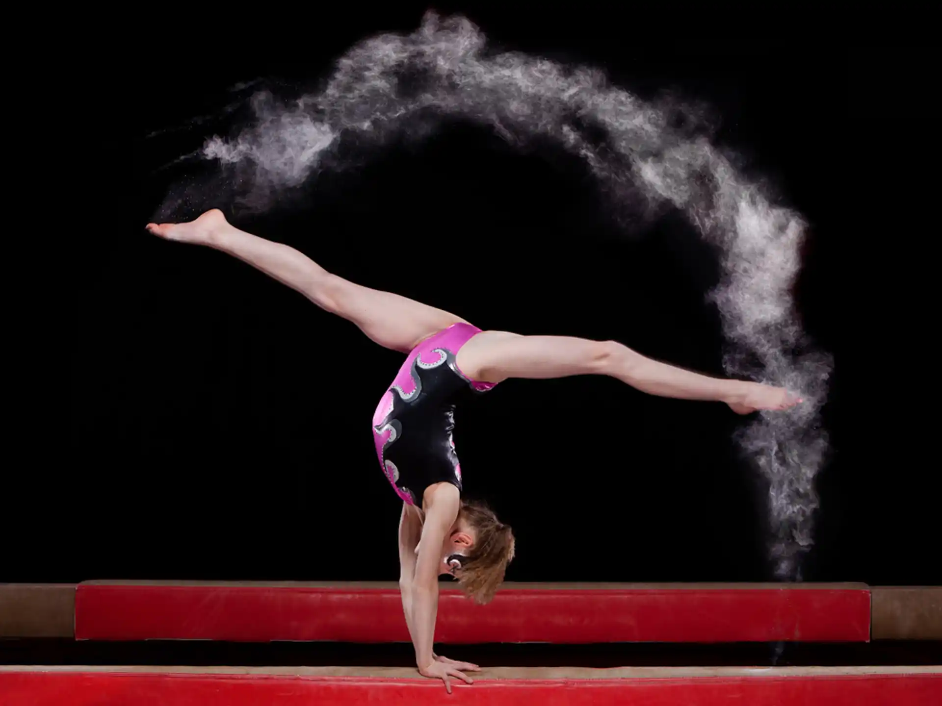 a woman doing a handstand on a stage