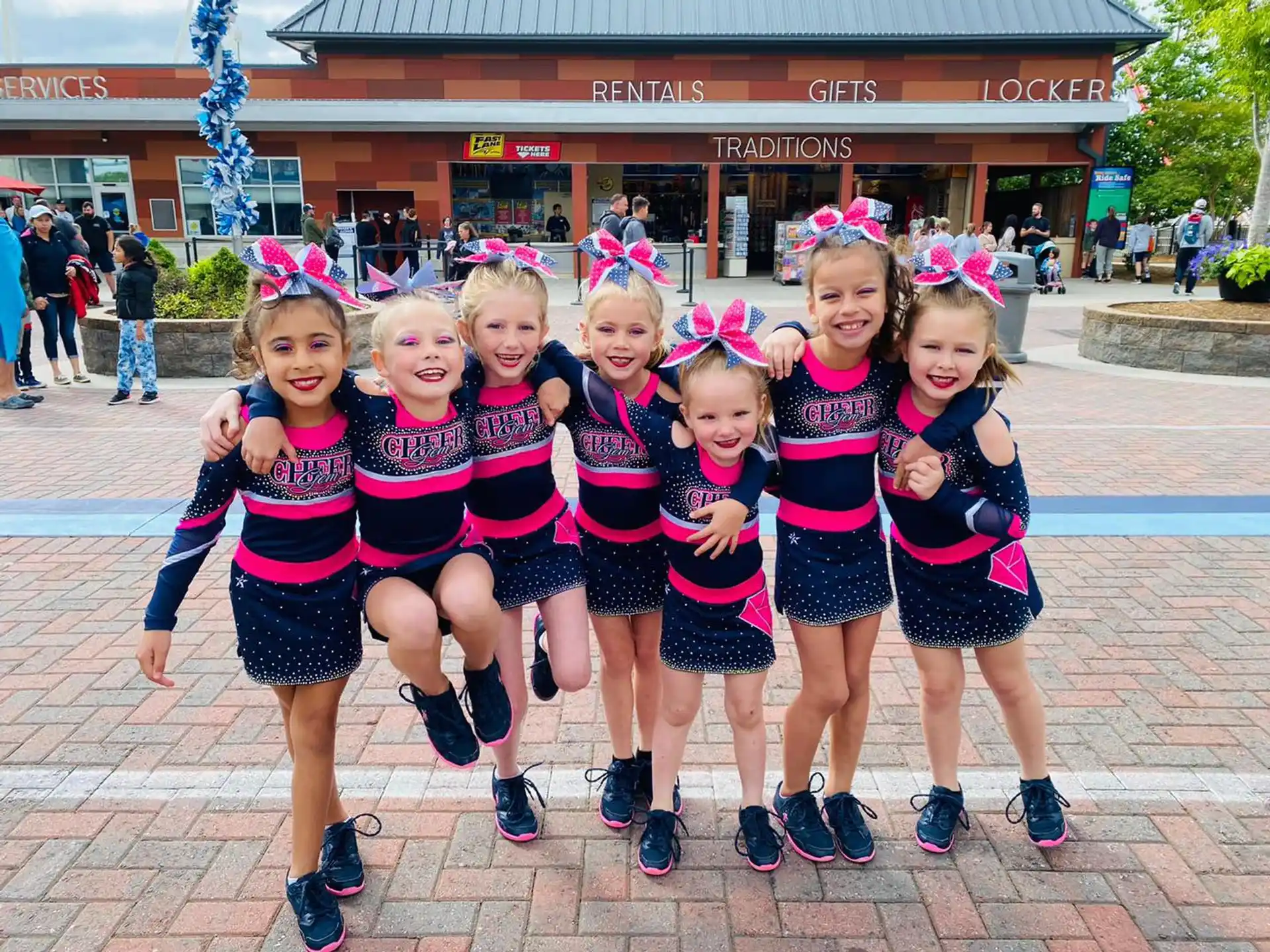 a group of girls in cheerleader uniforms posing for a photo