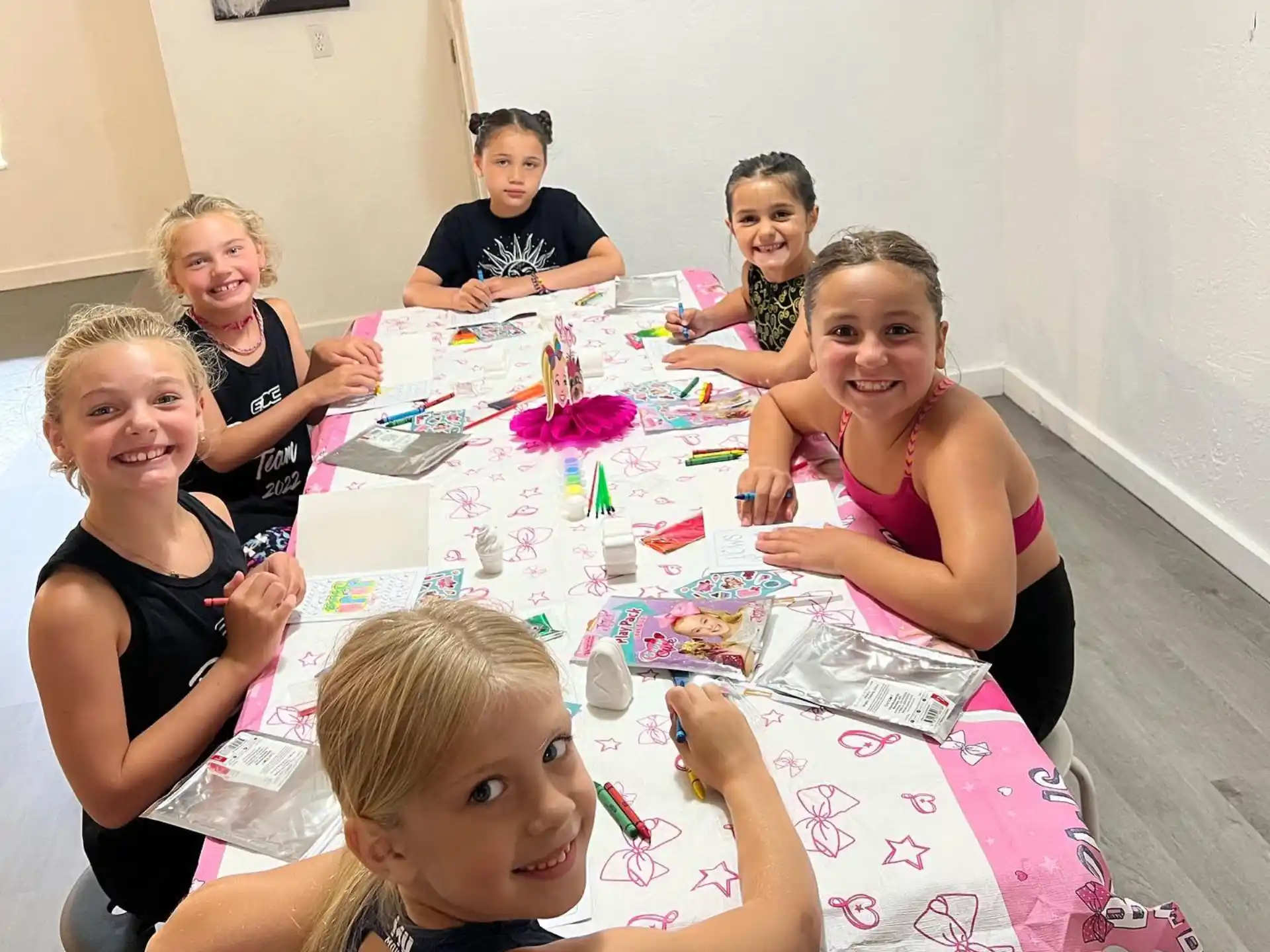 a group of people sitting around a table with a cake on it