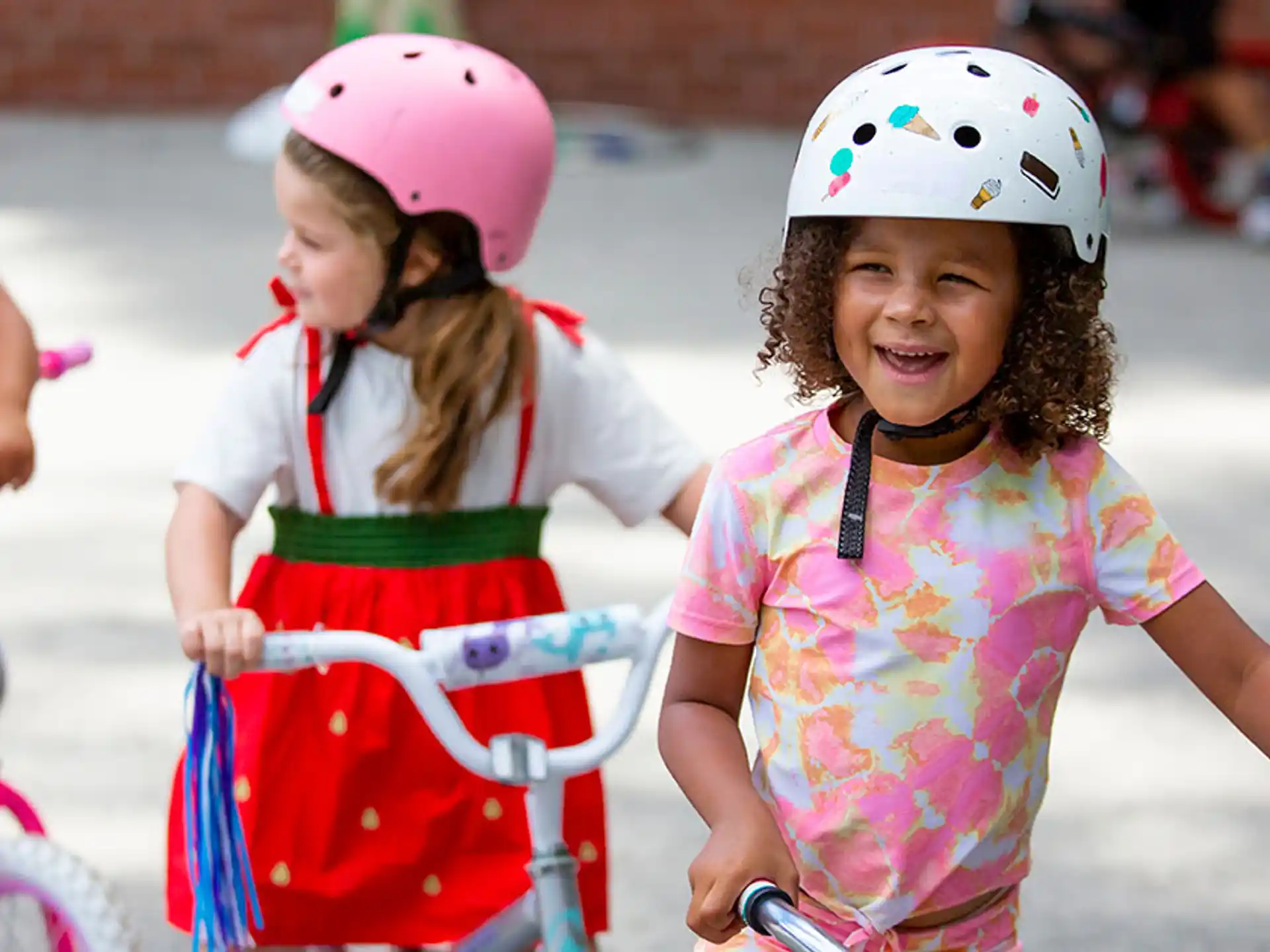 a group of children wearing helmets and riding bikes