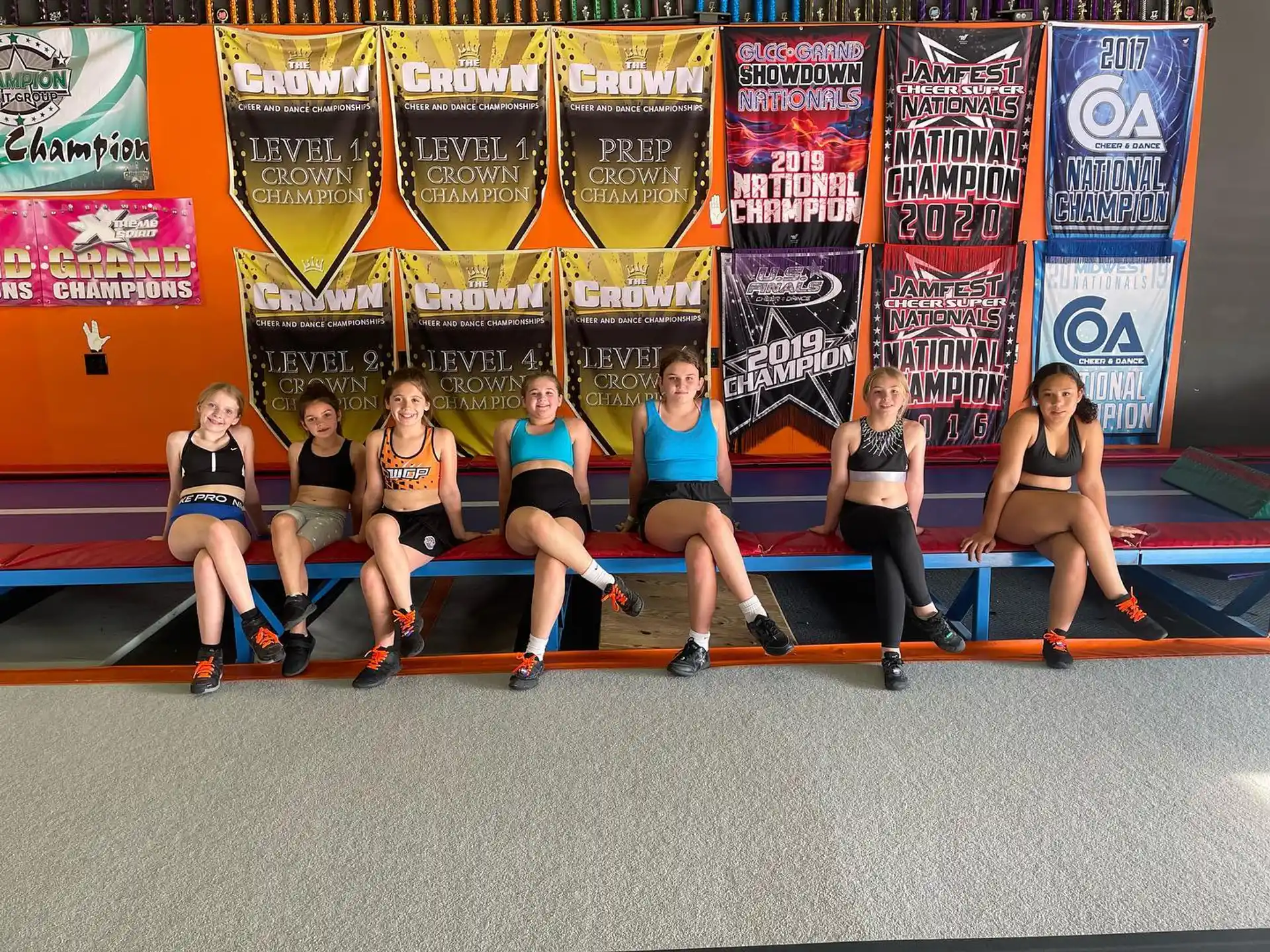 a group of women sitting on a bench in front of a wall