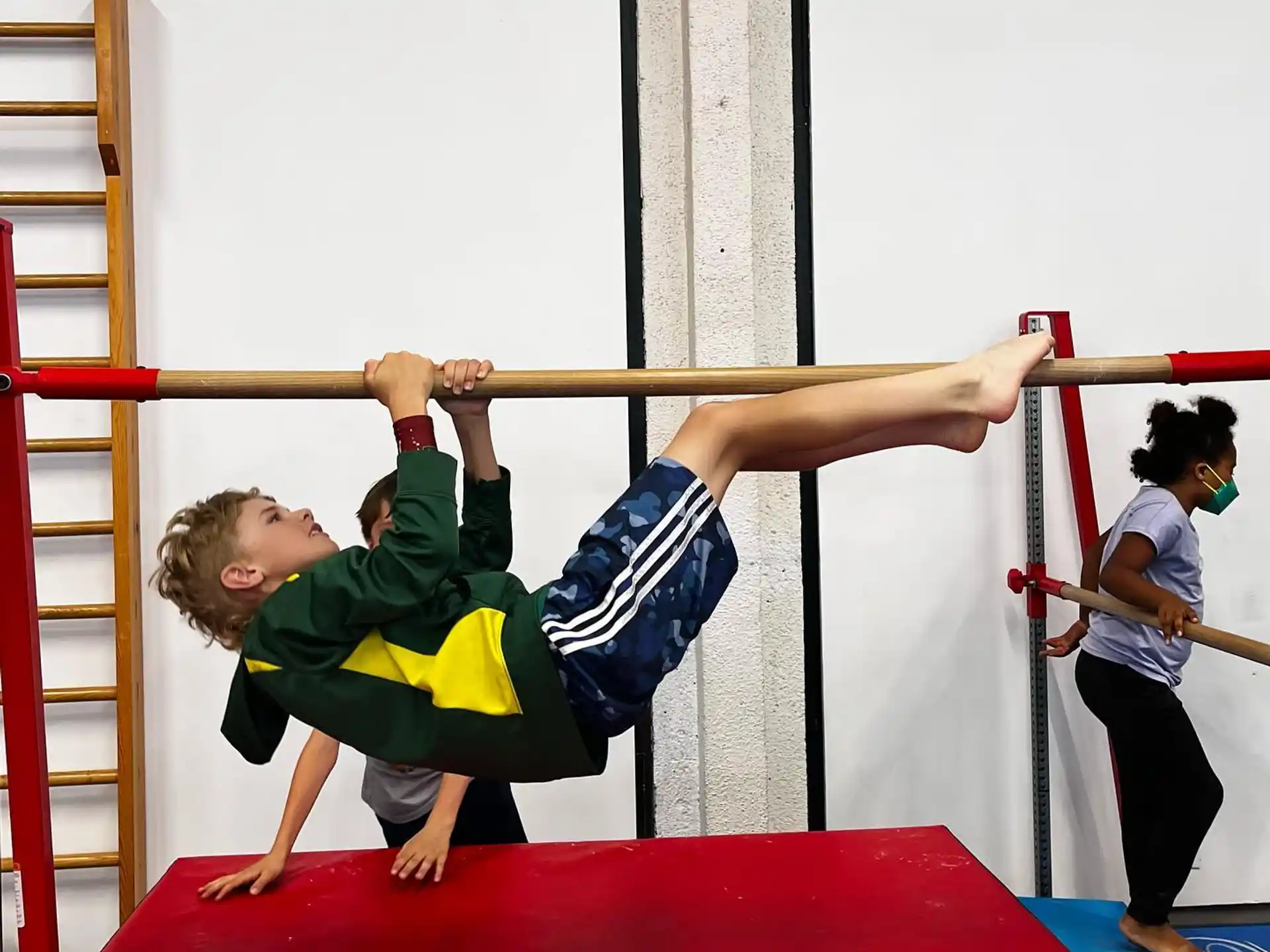 a boy doing a plank on a bar