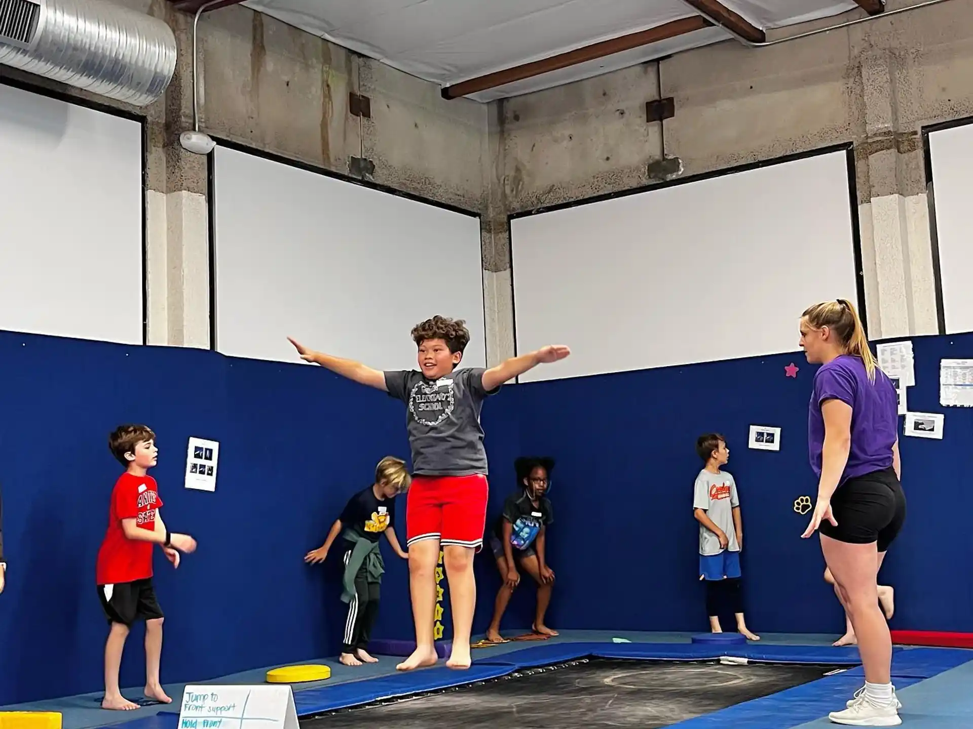 a group of people standing on a mat in front of a blue wall