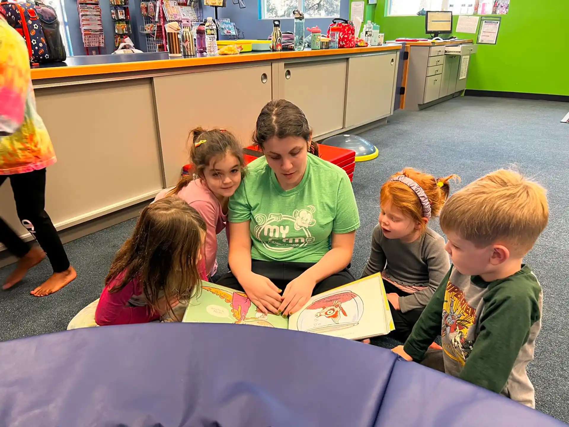a group of children sitting on the floor reading books