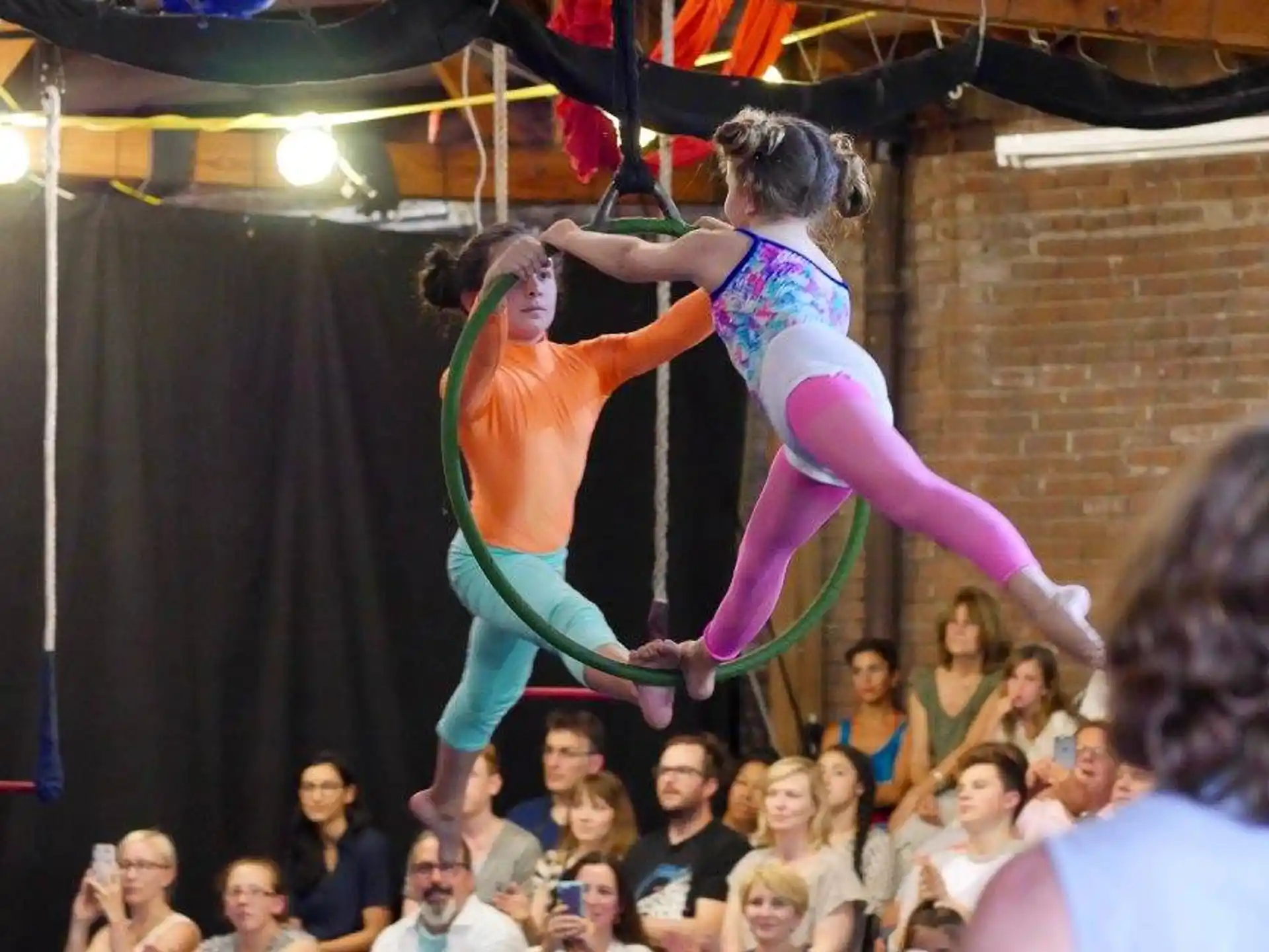 a couple of women dancing on a stage with a crowd watching