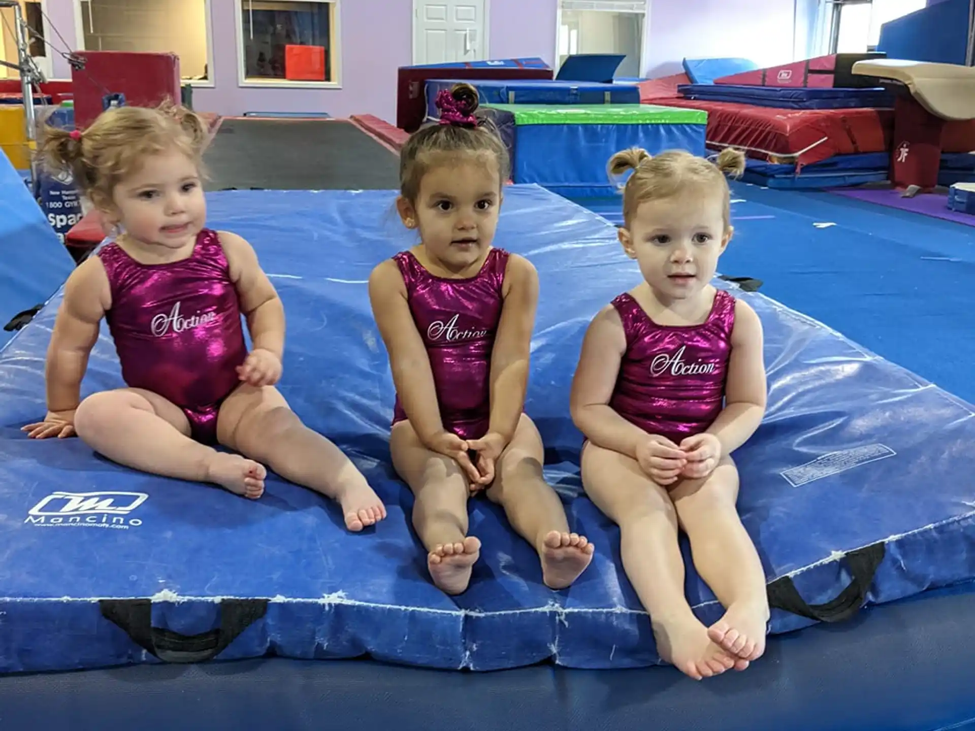 a group of children sitting on a mat in a room