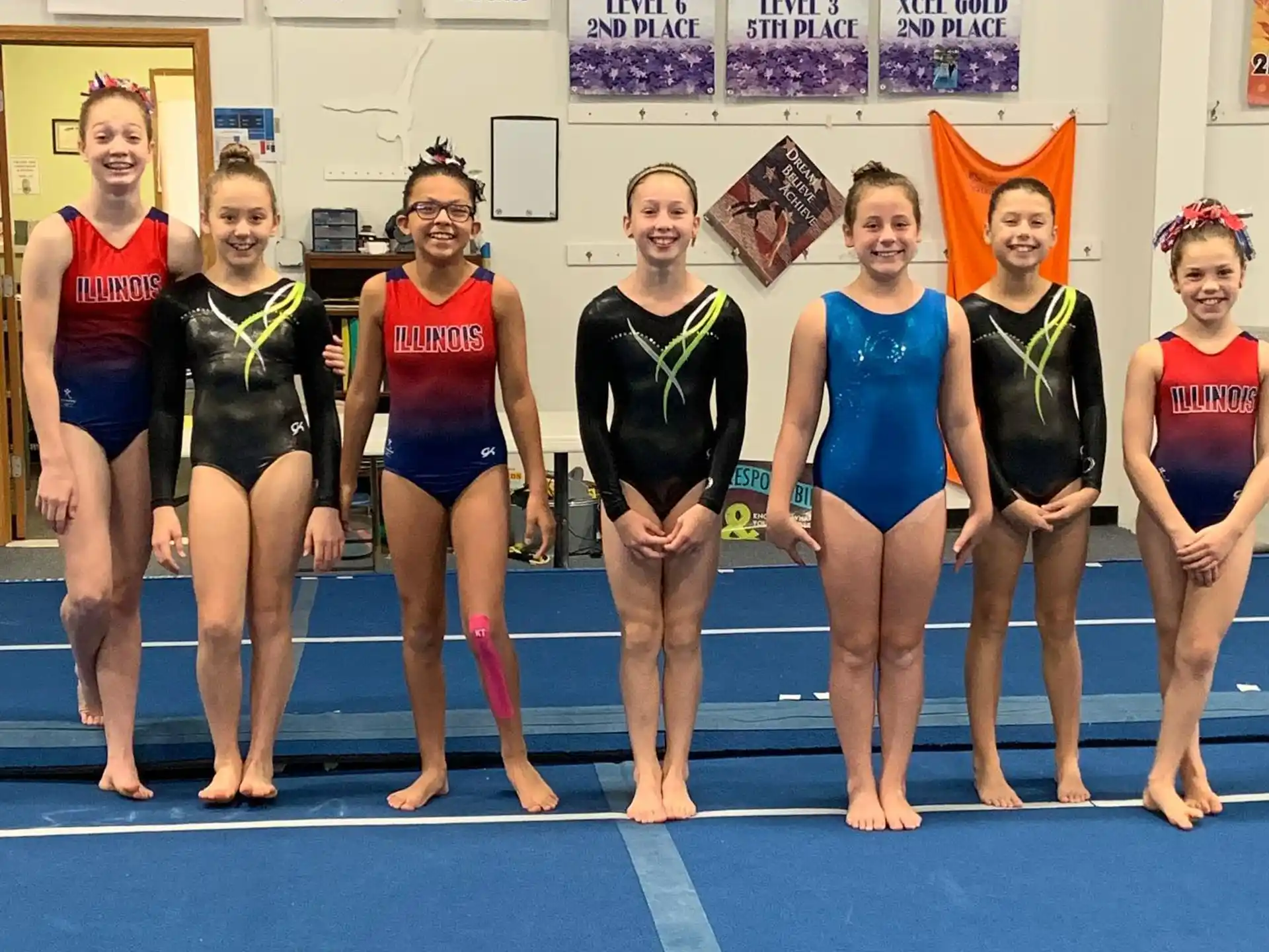 a group of women in leotards posing for a photo
