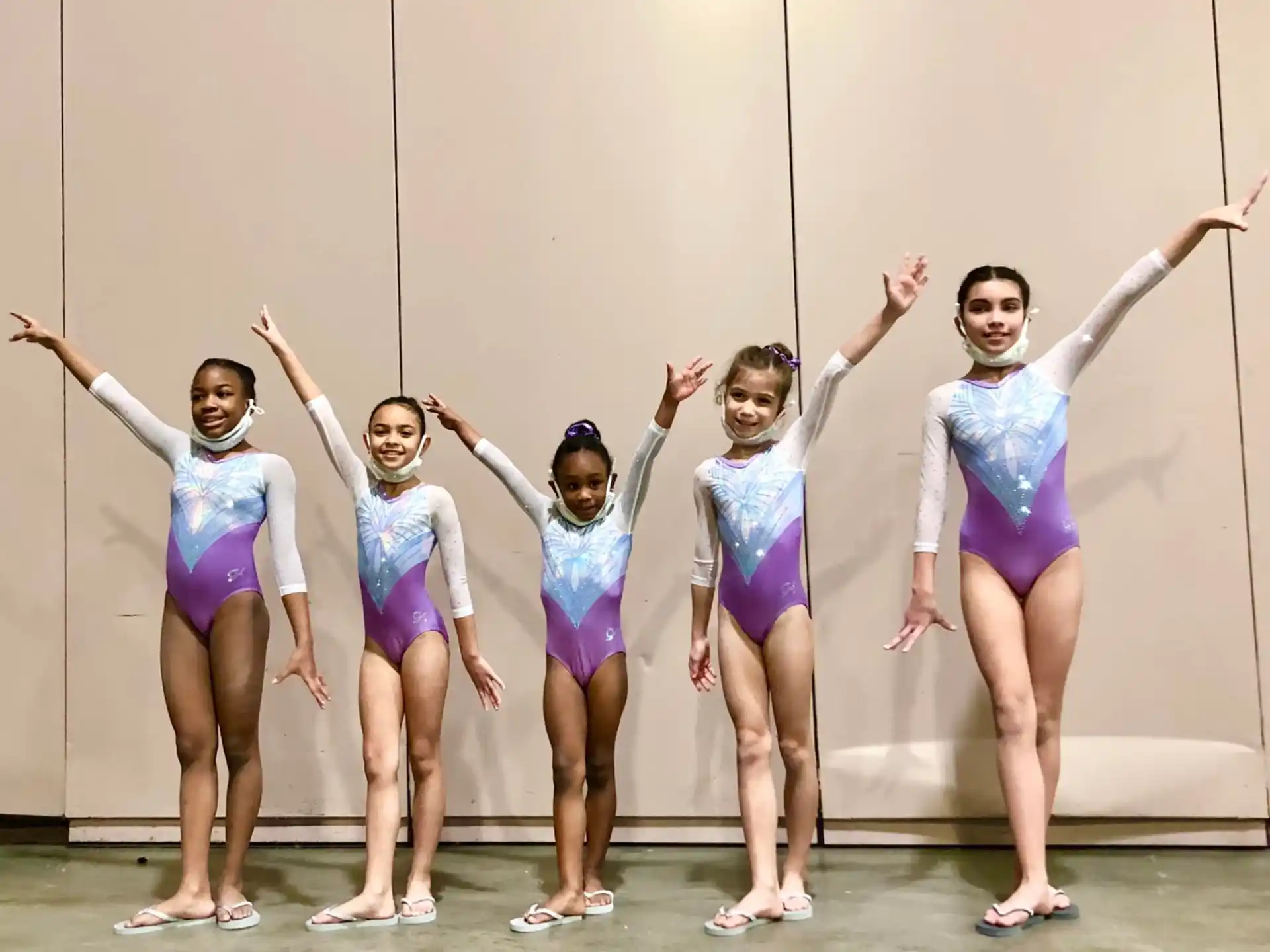 a group of girls in leotards posing for a photo