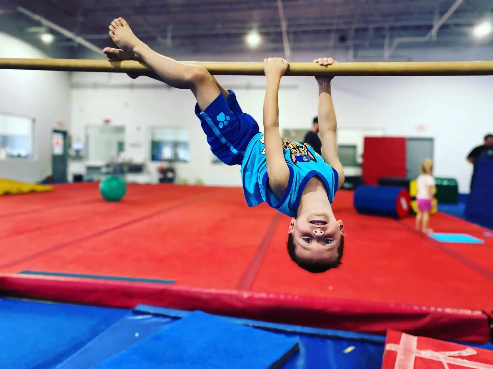 a person doing a handstand on a mat in a gym
