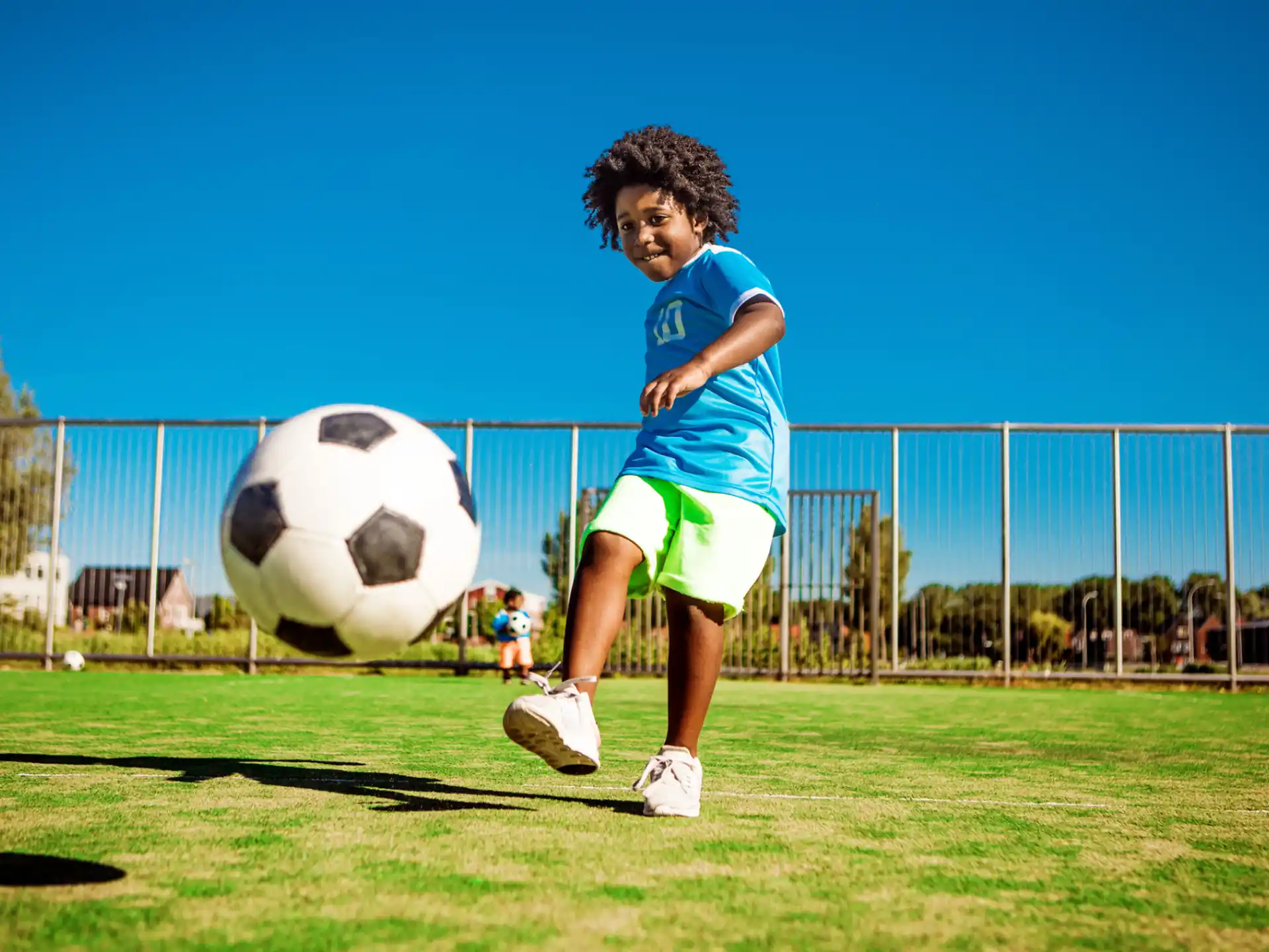 a kid kicking a football ball
