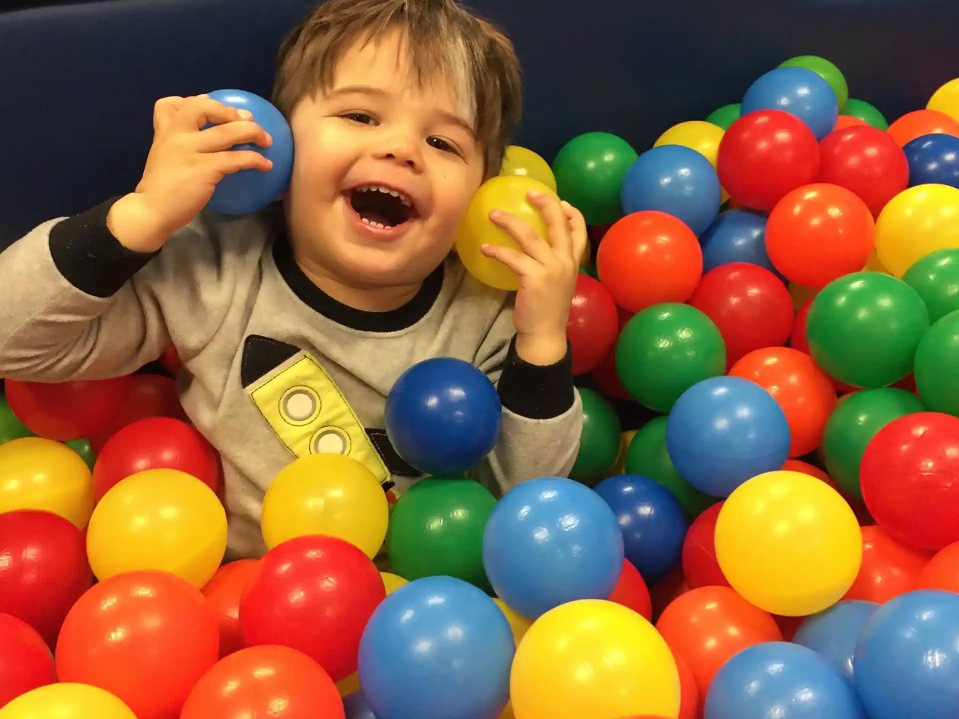 a boy in a ball pit