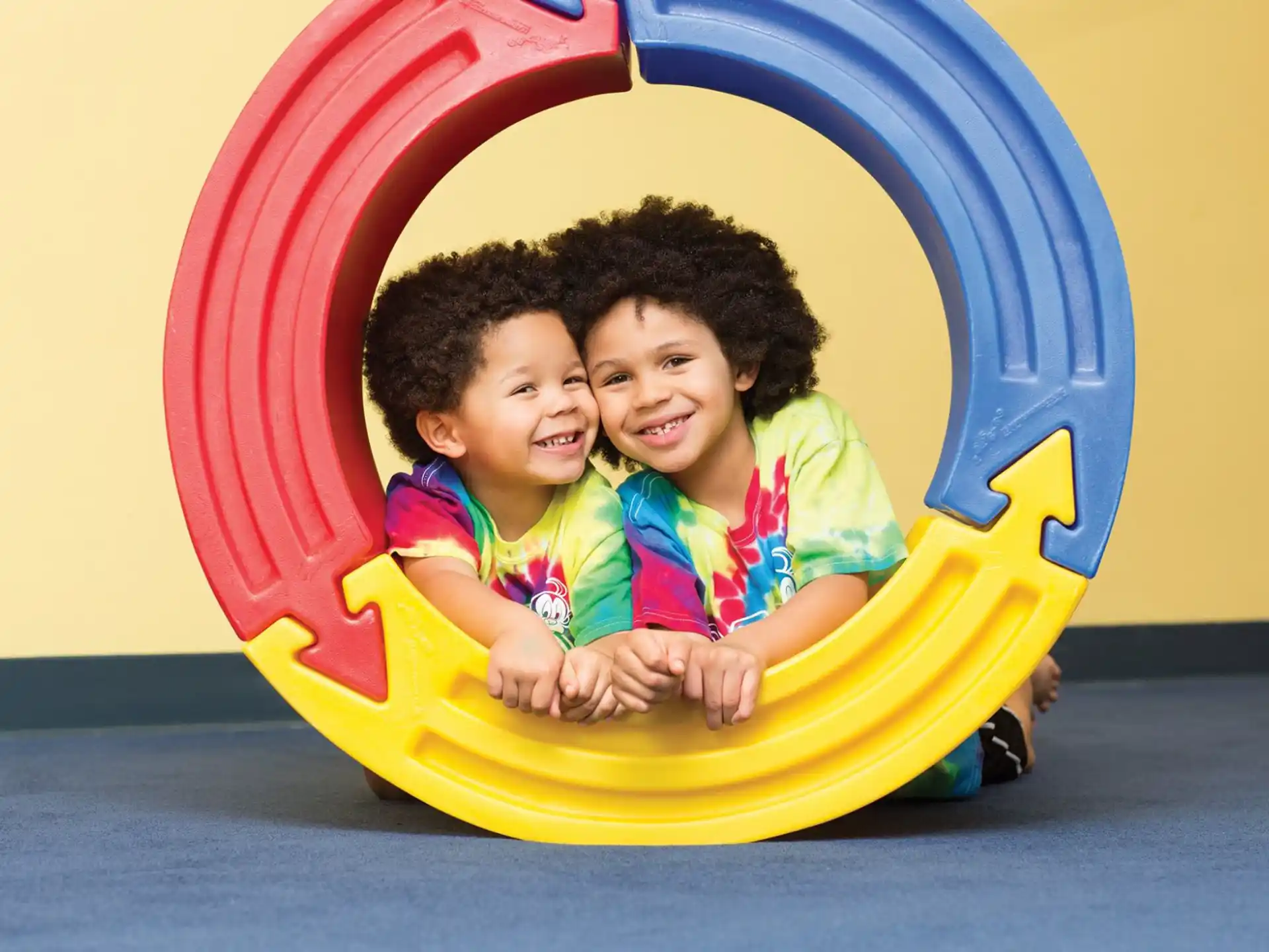 a couple of children in a yellow and red slide