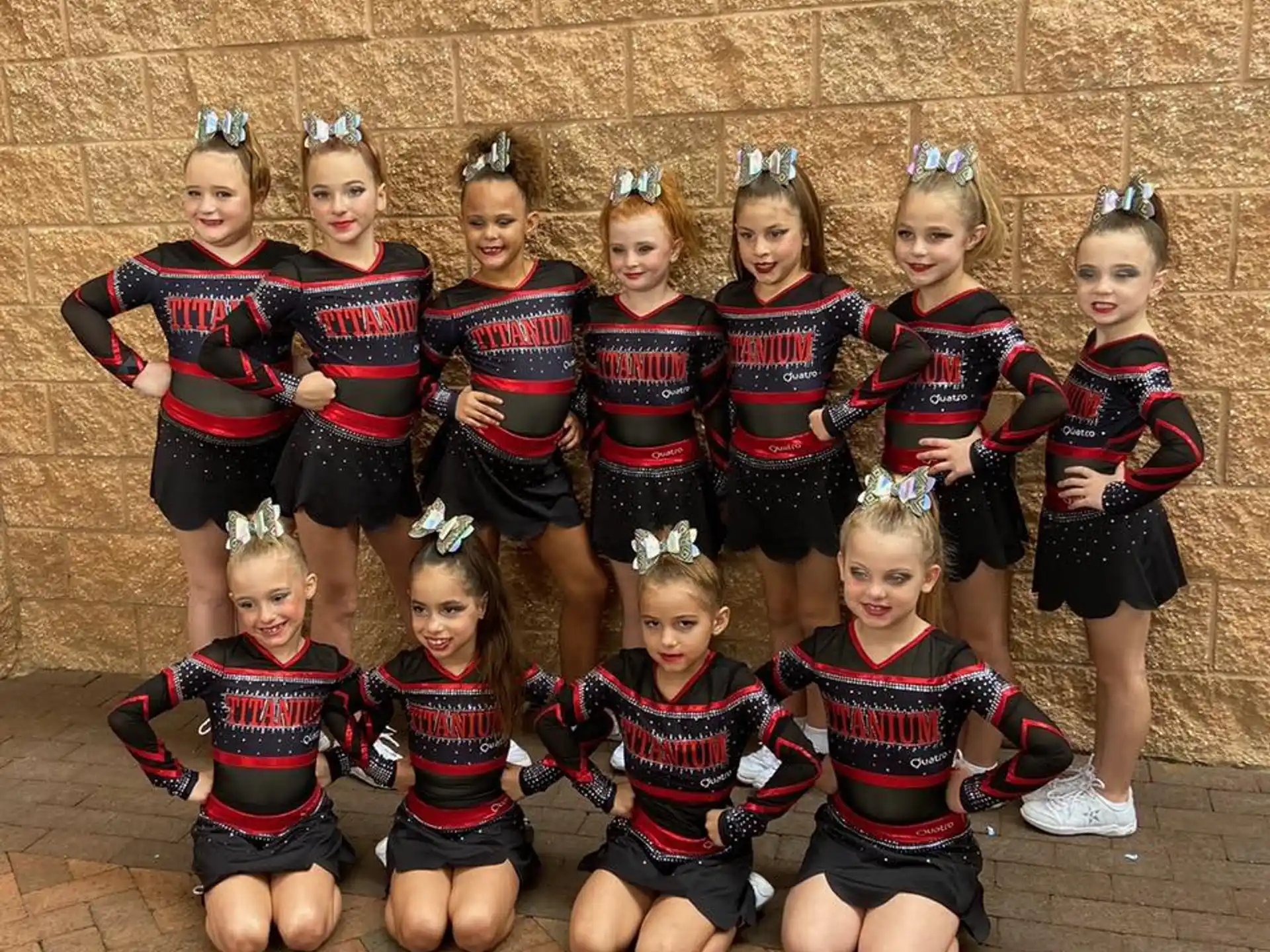 a group of girls in matching red and black striped shirts