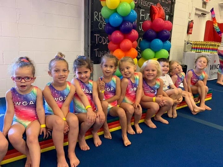 a group of children sitting on a couch with balloons