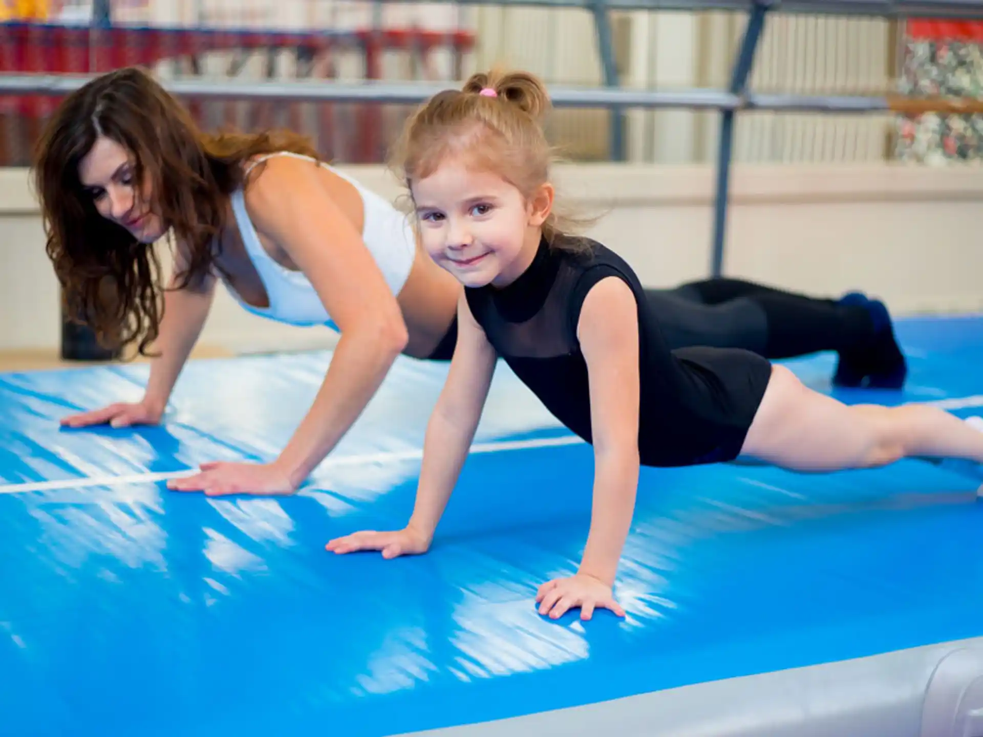 a couple of girls on a blue mat in a swimming pool