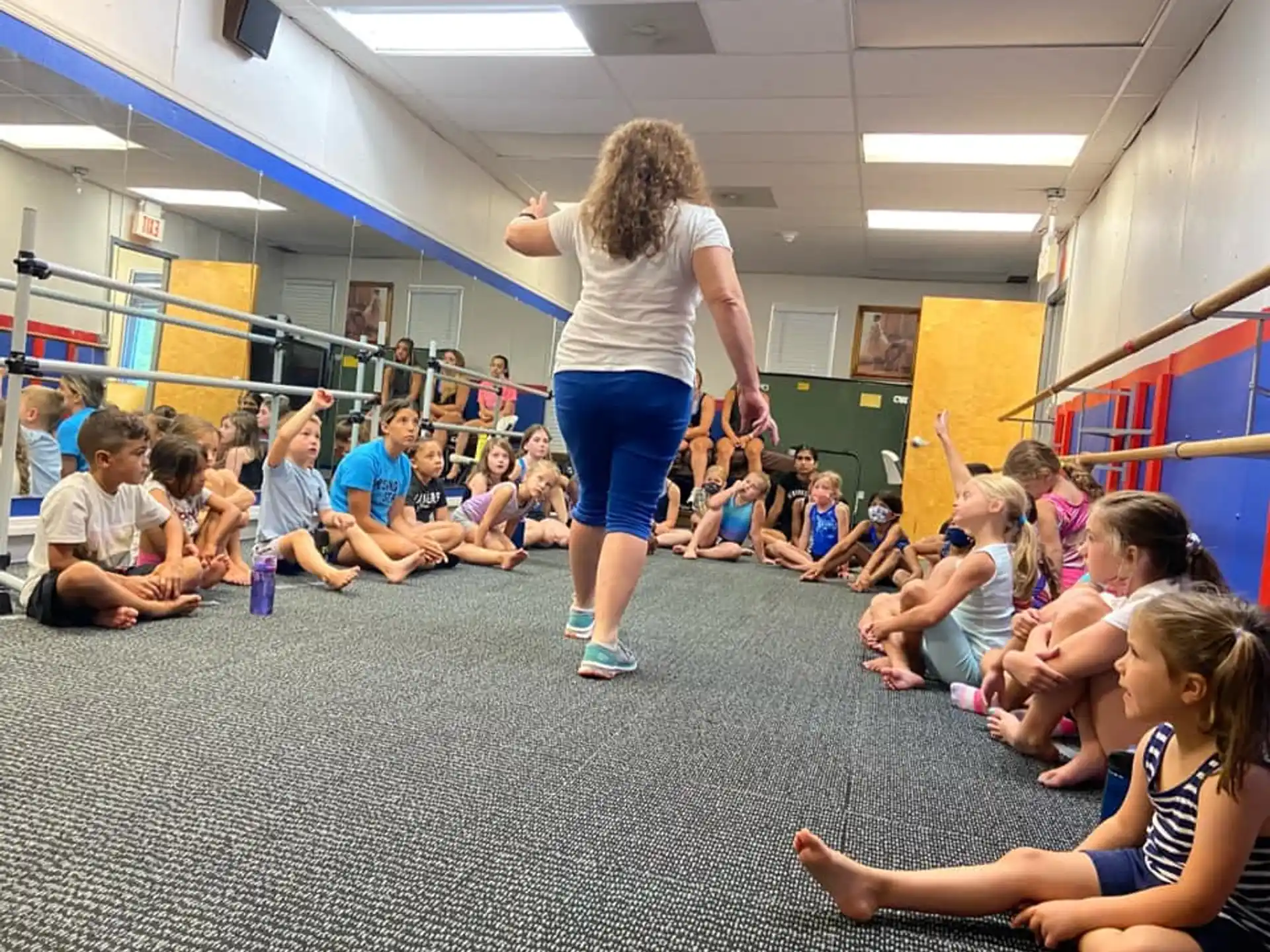 a woman standing on her hands in front of a group of people