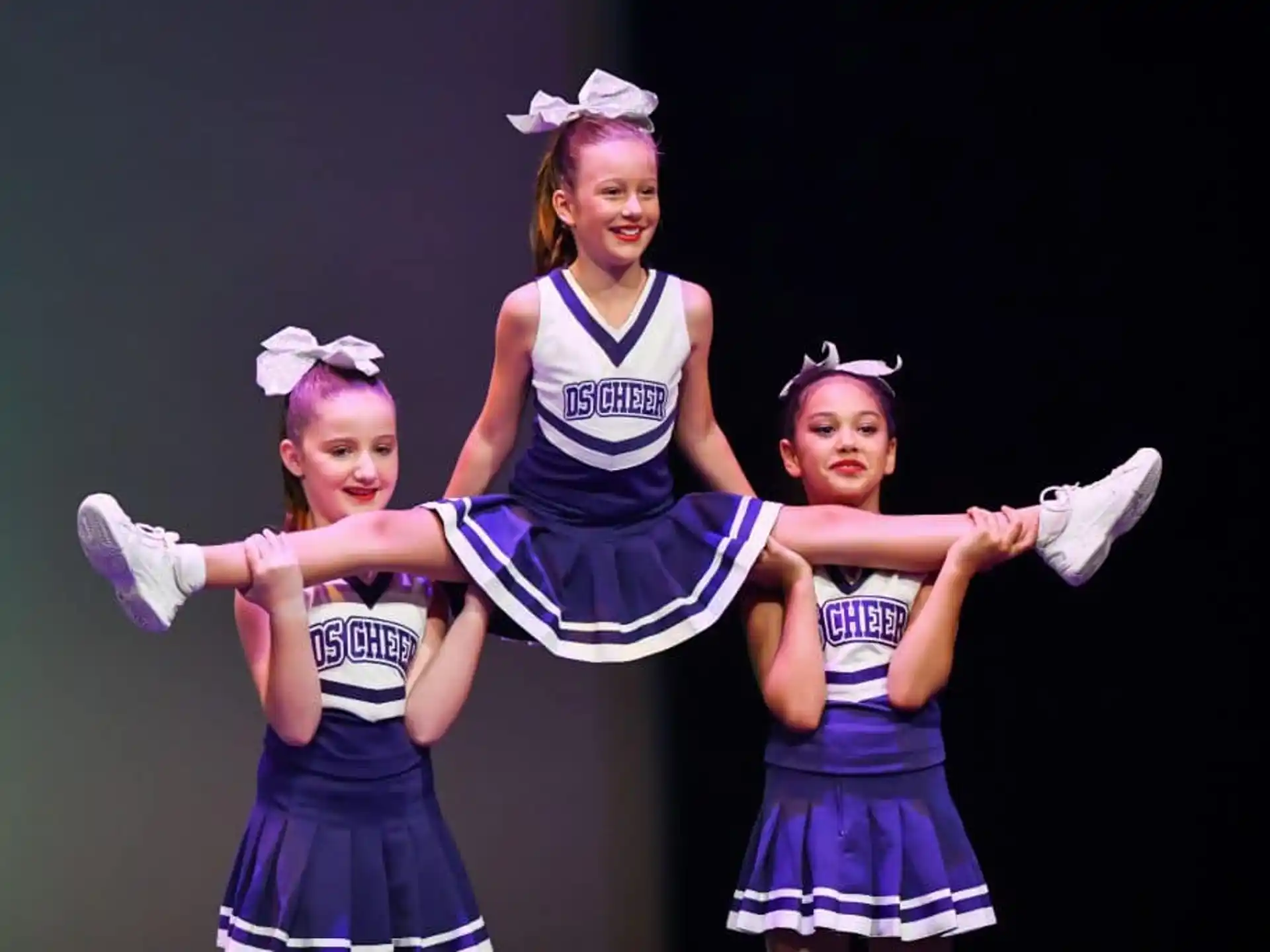 a group of girls in blue and white dresses dancing