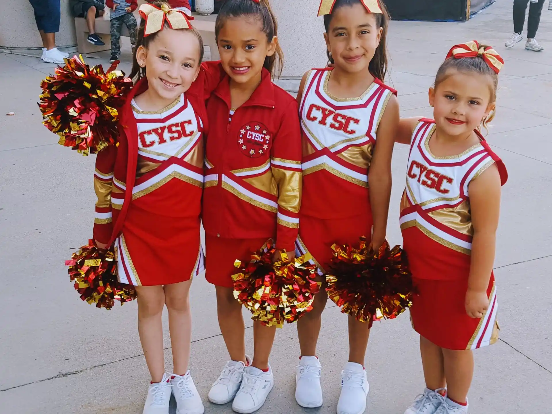 a group of girls in red and white uniforms with flowers