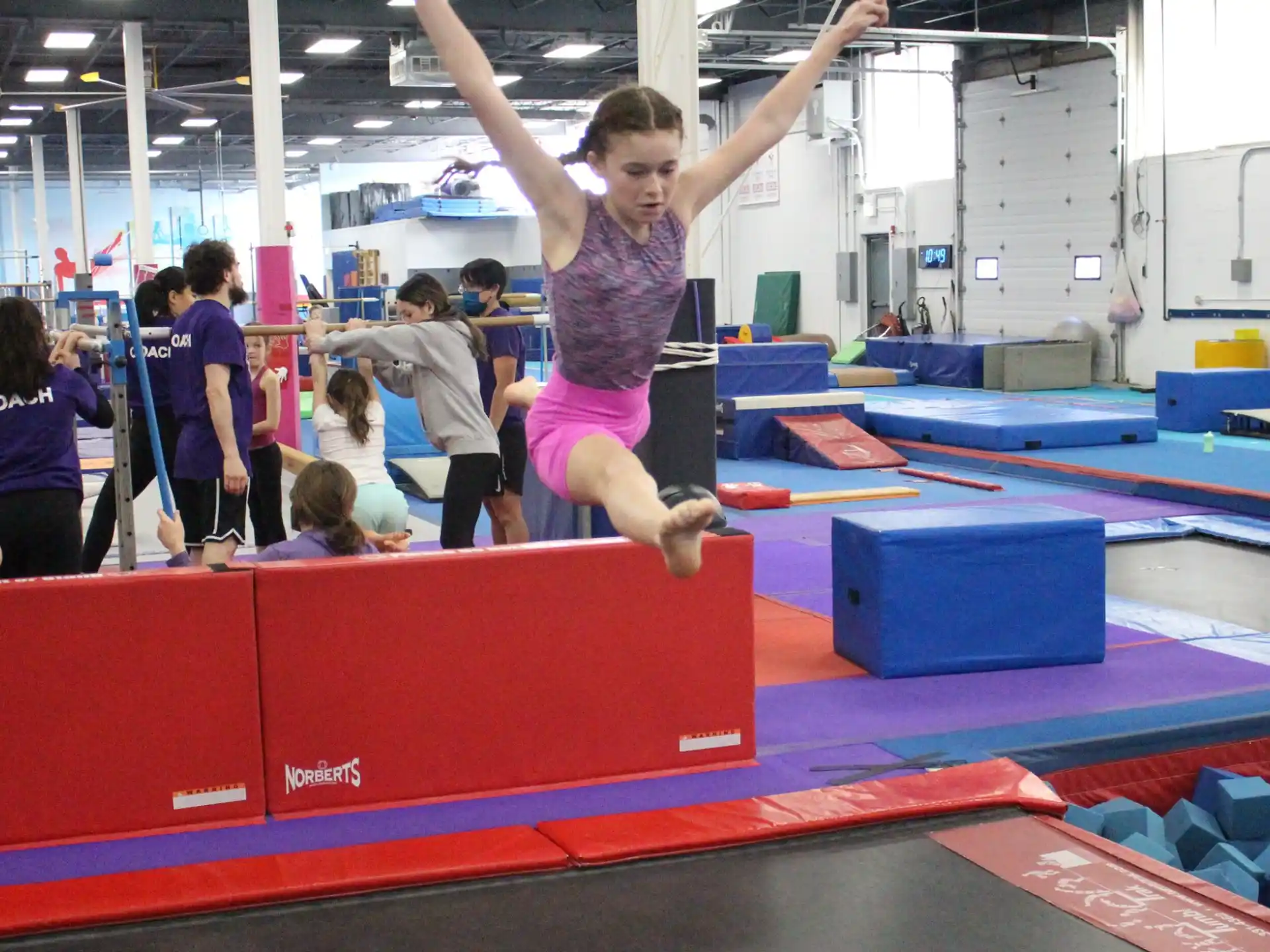 a girl jumping on a mat