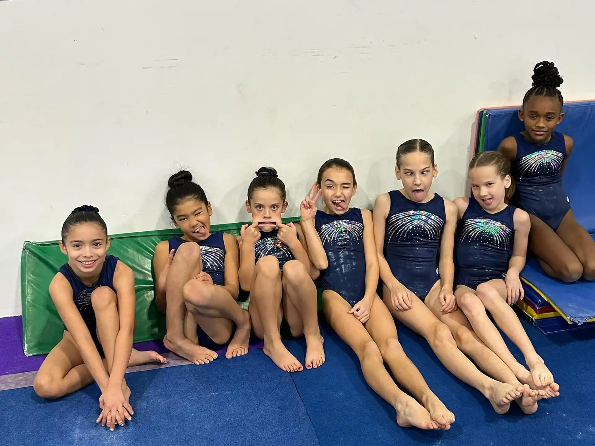 a group of children in swimsuits on a blue mat