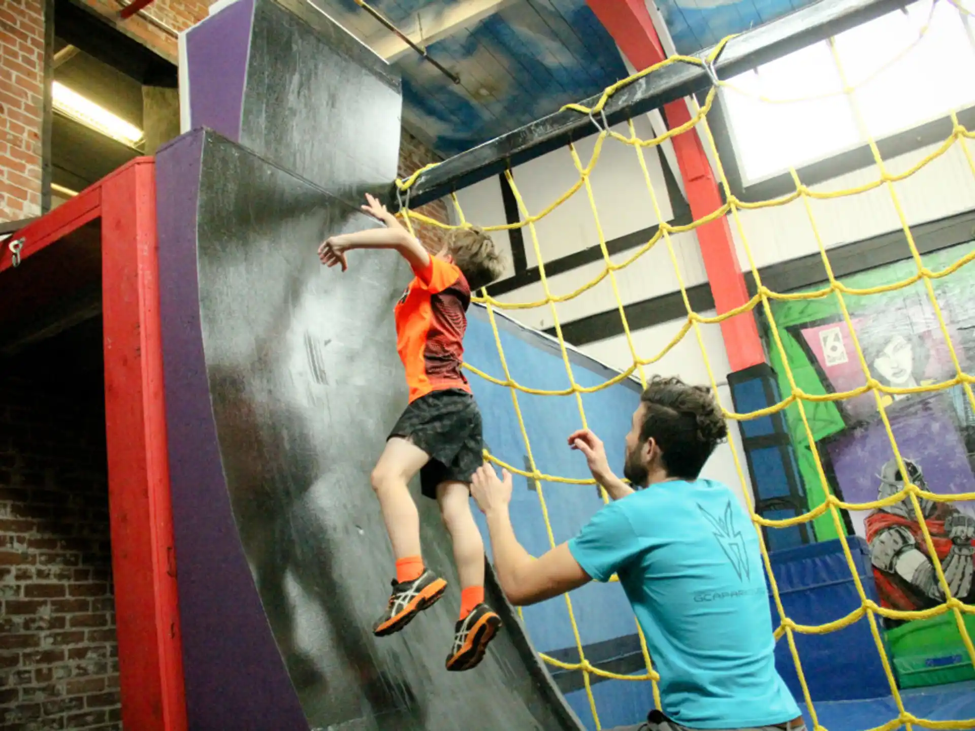 a man and a woman climbing a wall