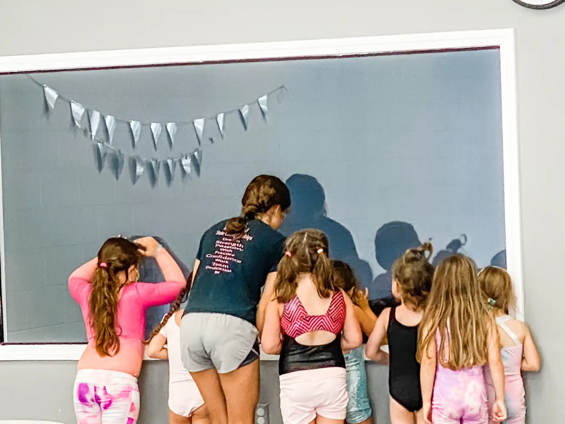 a group of girls standing in front of a chalkboard