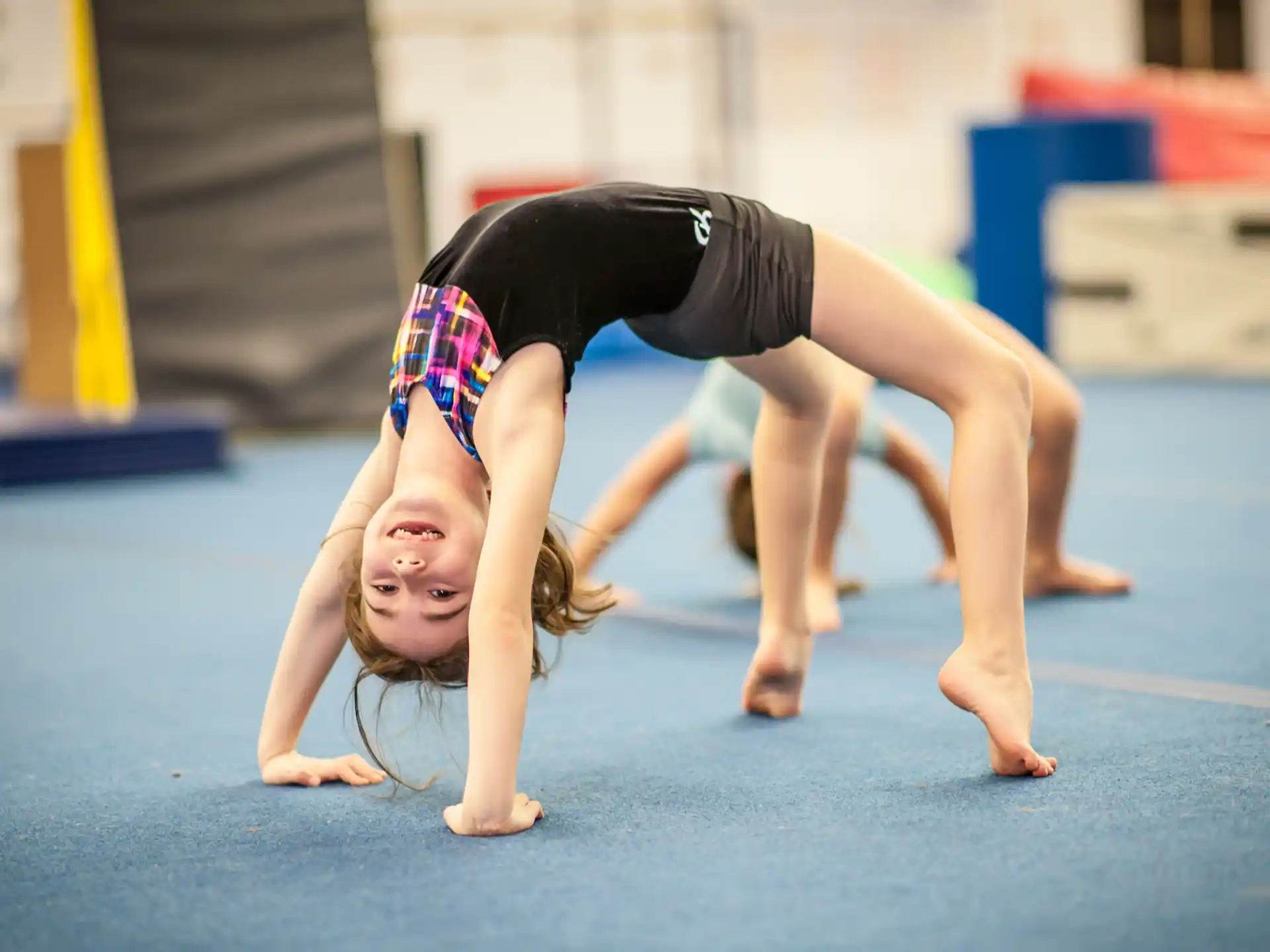 a woman doing a handstand on a mat