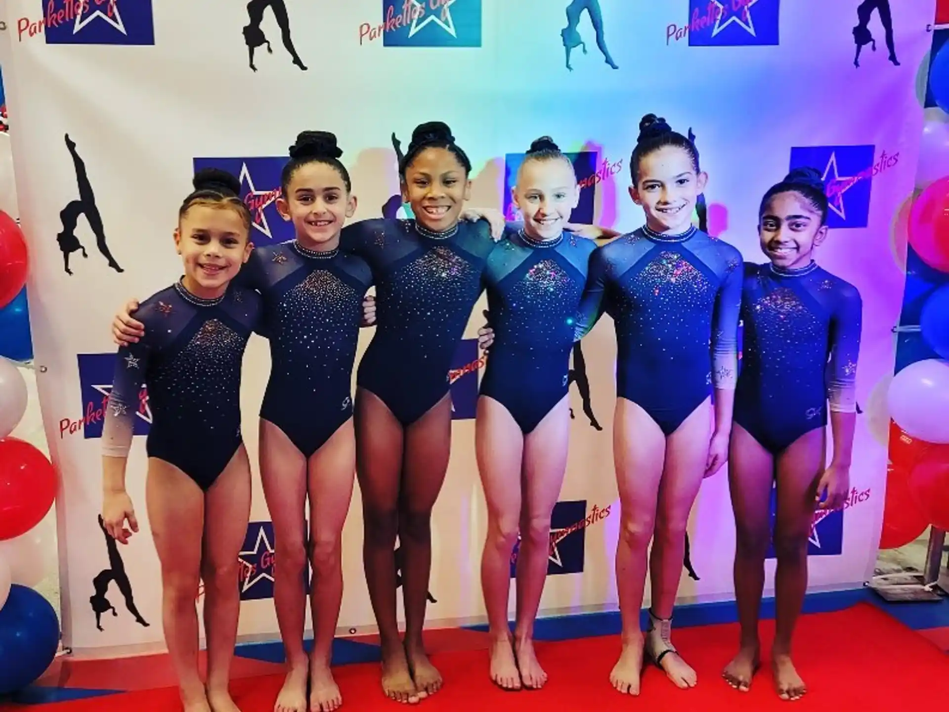 a group of women in leotards posing for a photo