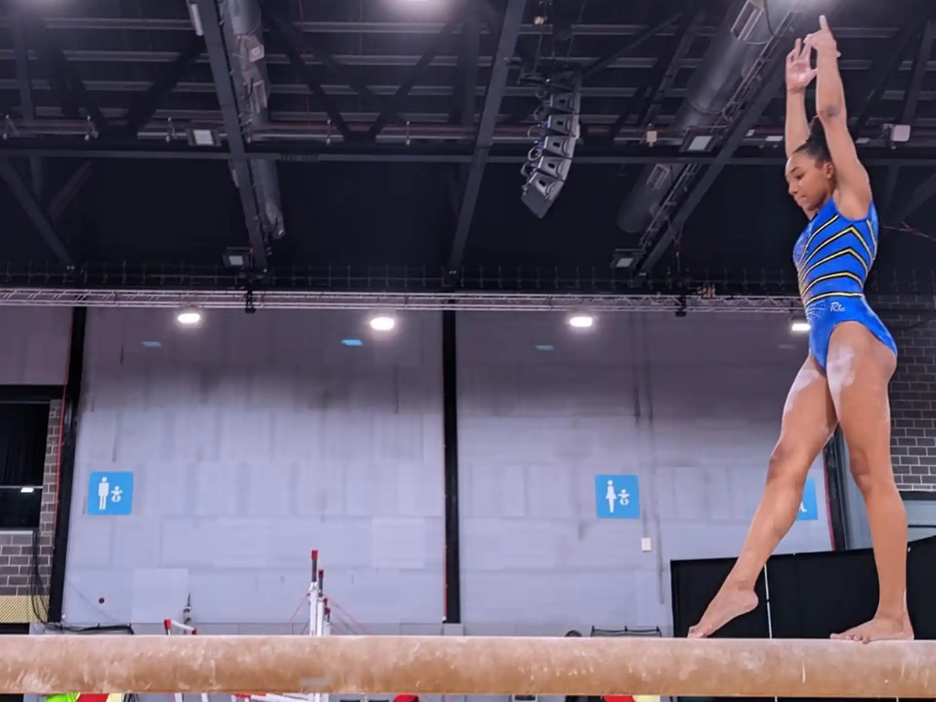 a woman in a blue leotard doing a high jump