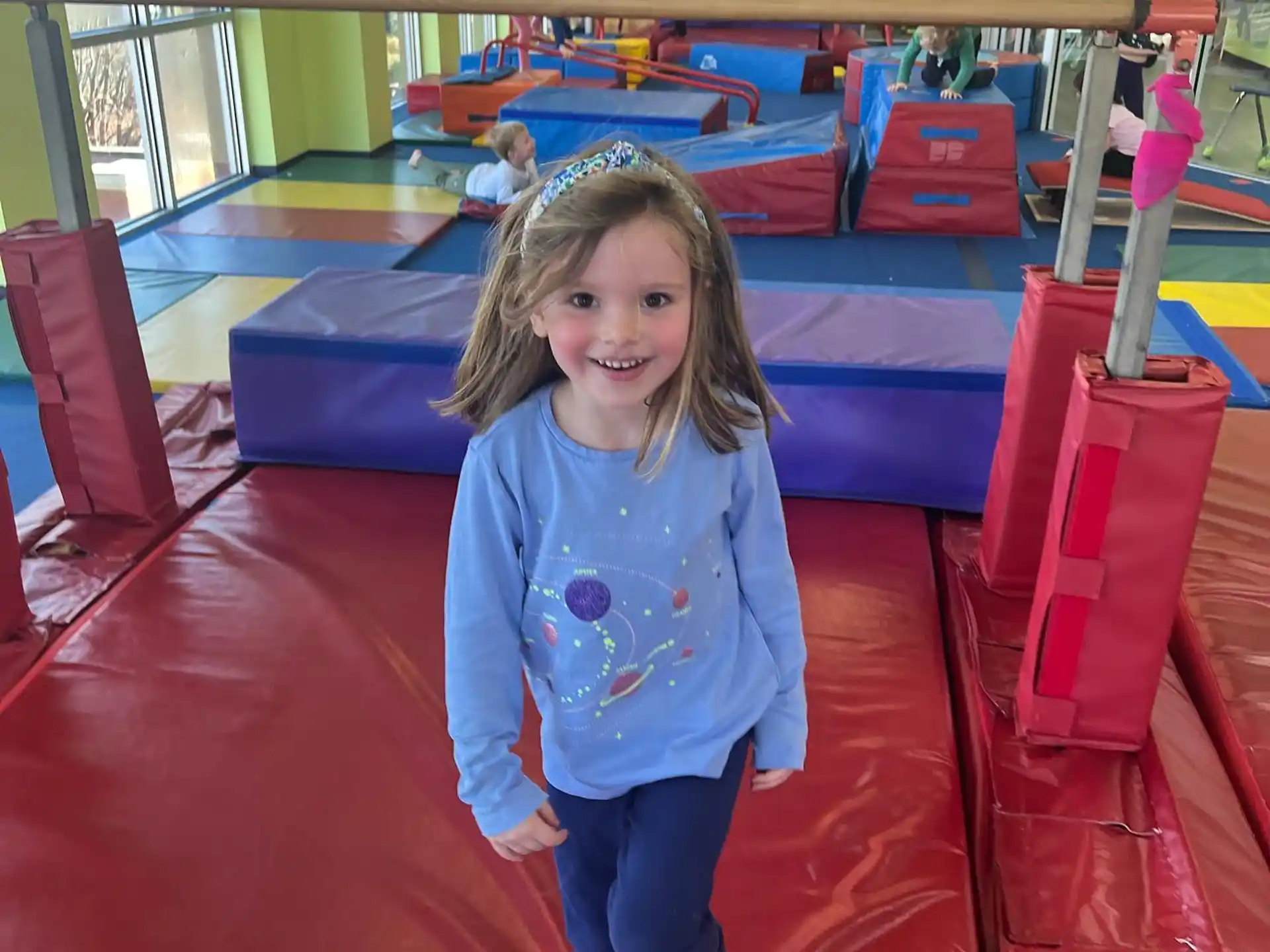 a girl standing on a red carpet in a gym
