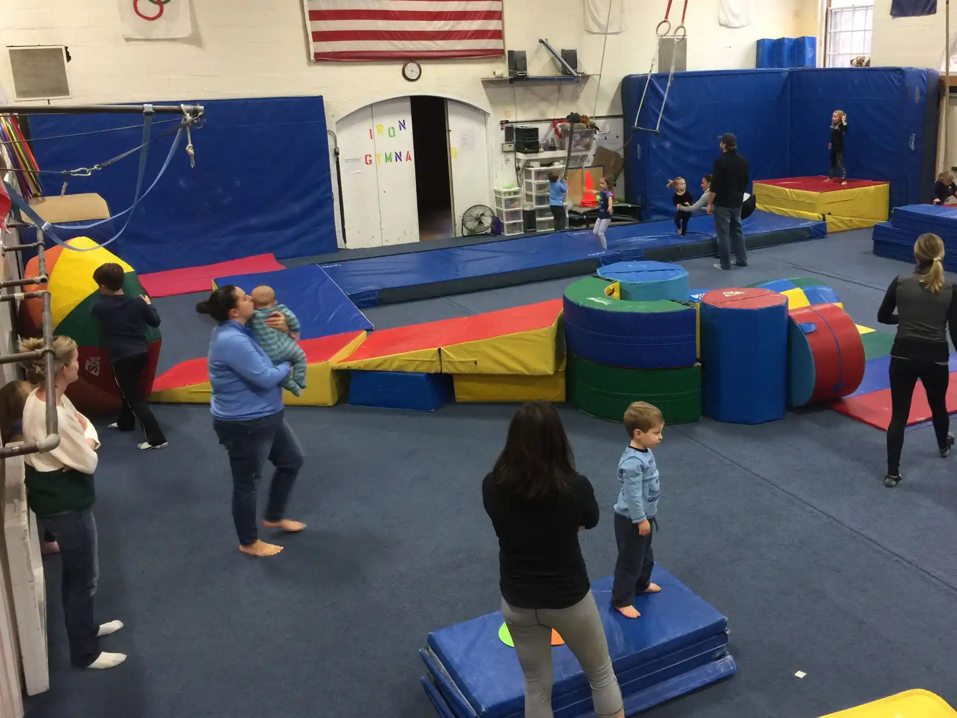 a group of people playing in a room with blue and red tents