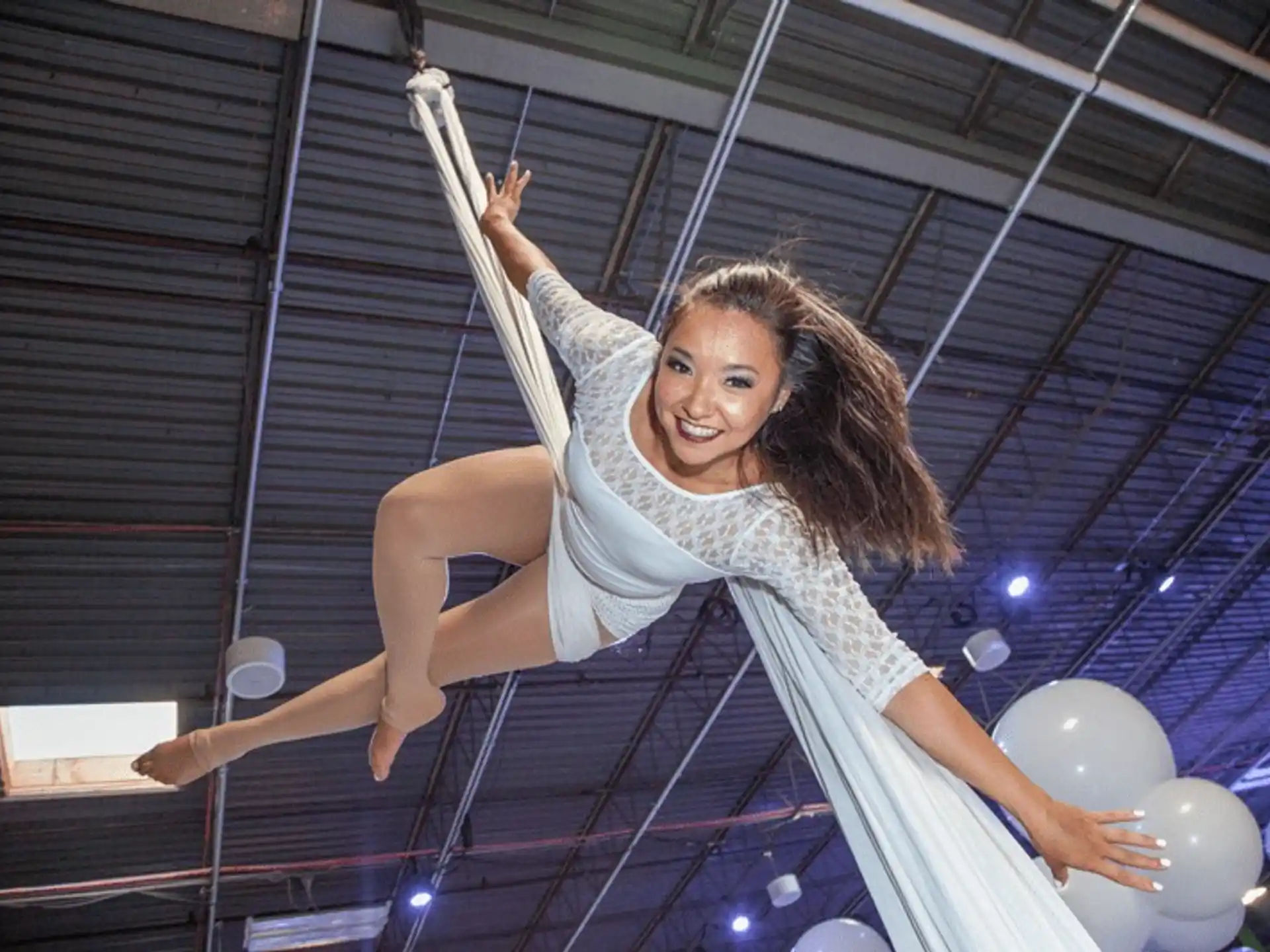a person in a white dress jumping on a rope