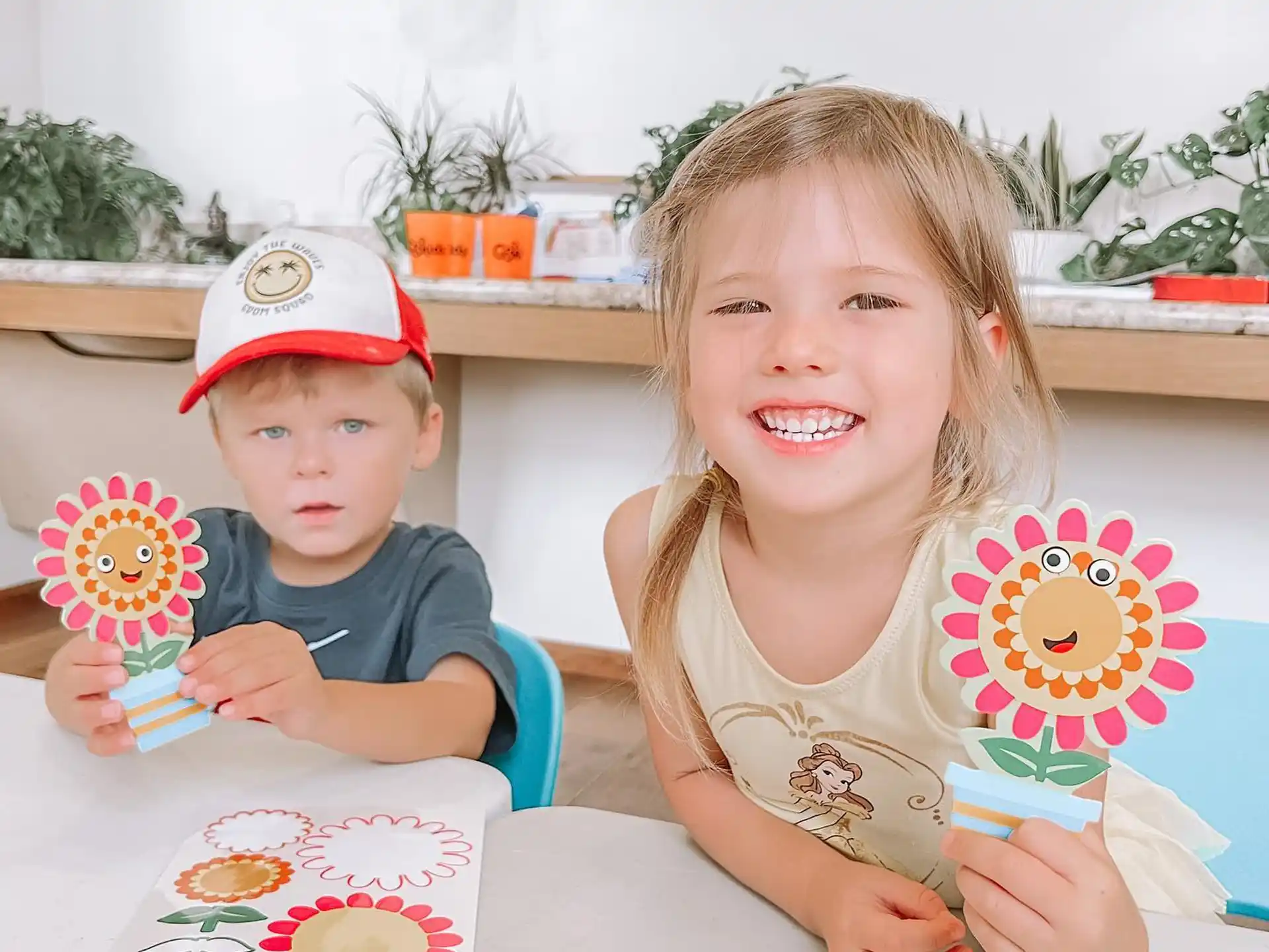 a couple of children sitting at a table with a cake