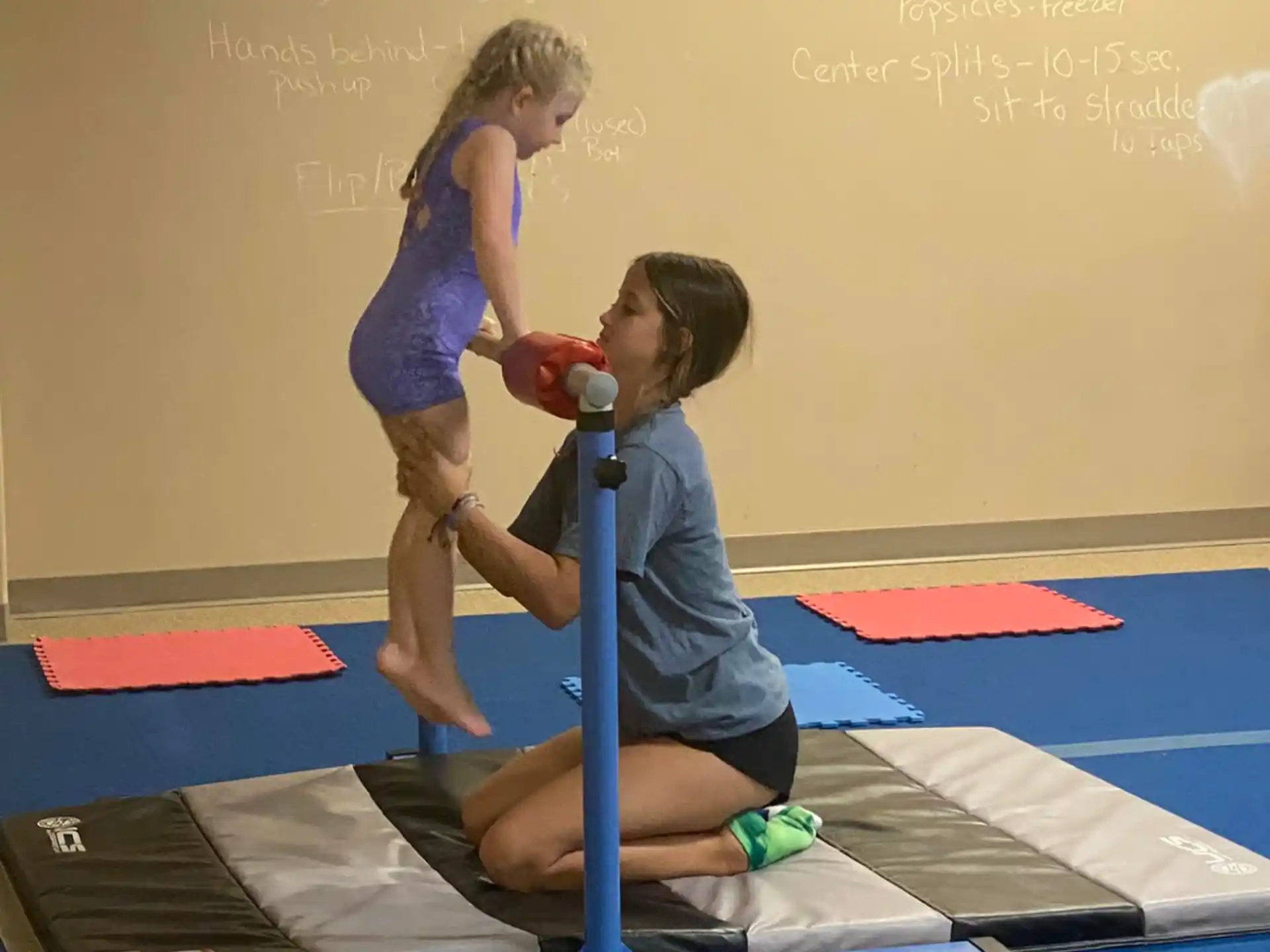 a person teaching a girl how to use a scooter